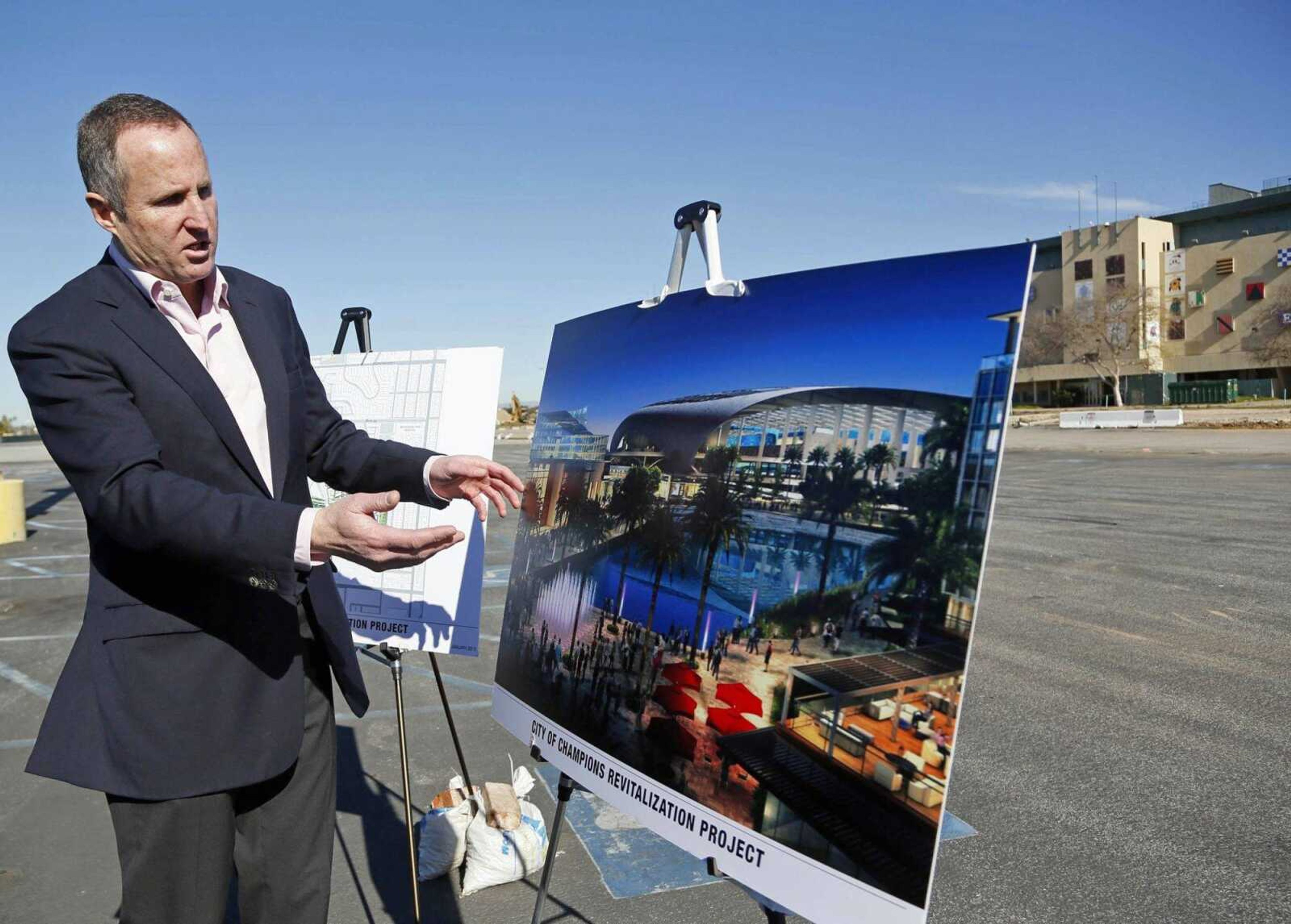 Chris Meany, senior vice president of Hollywood Park Land Co., on Jan. 5, 2015, unveils an architectural rendering of a proposed NFL stadium at Hollywood Park in Inglewood, California. The Rams' relocation application says the NFL would benefit from the team's move to Los Angeles, leaving behind a lagging St. Louis market and a stadium proposal doomed for failure. (Nick Ut ~ Associated Press)