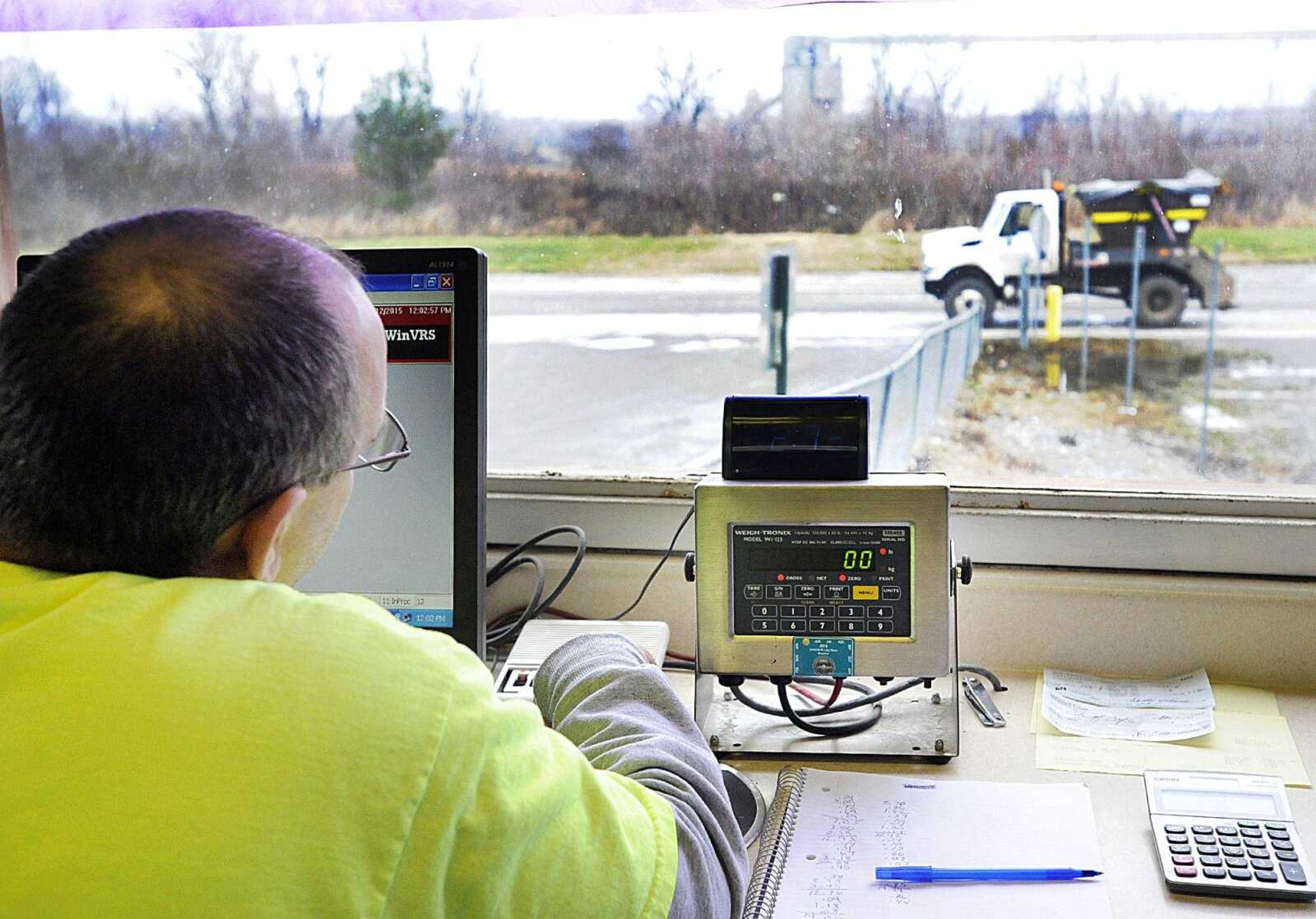 David Groves, the scale operator at Cape Girardeau Public Works Department's transfer station, speaks with the driver dropping off  a load of waste in a lugger Monday. Groves tallies the weight of each load of waste dropped off until they have 25 tons in one shipping container before bringing in an empty container. (Laura Simon)