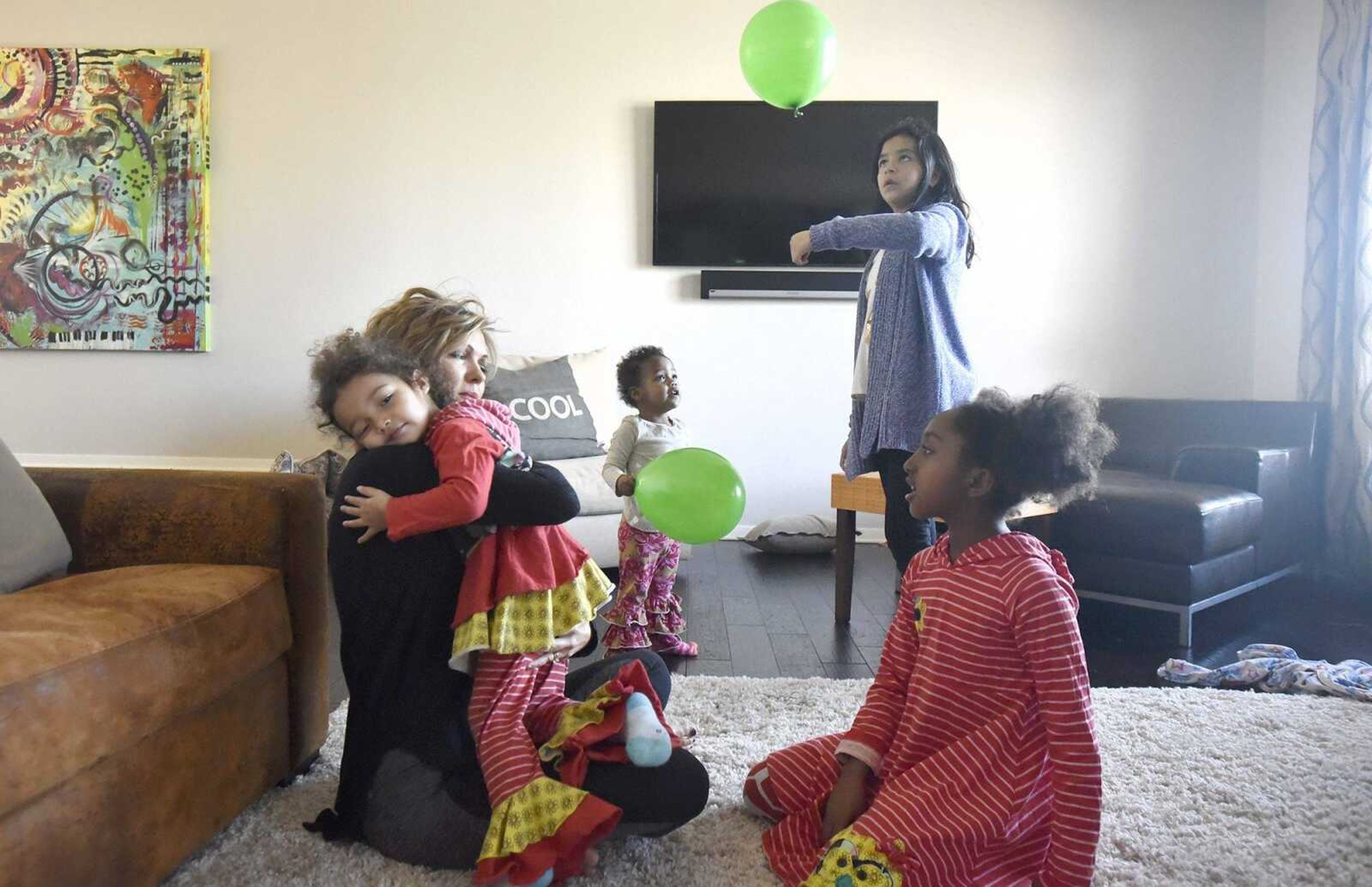 Chantelle Becking embraces Dolly, 3, as her other daughters, Lennyx, 1, Bianca, 10, and Solie, 8, play in the family room on Saturday, Jan. 28, 2017, at the Becking's Cape Girardeau home.