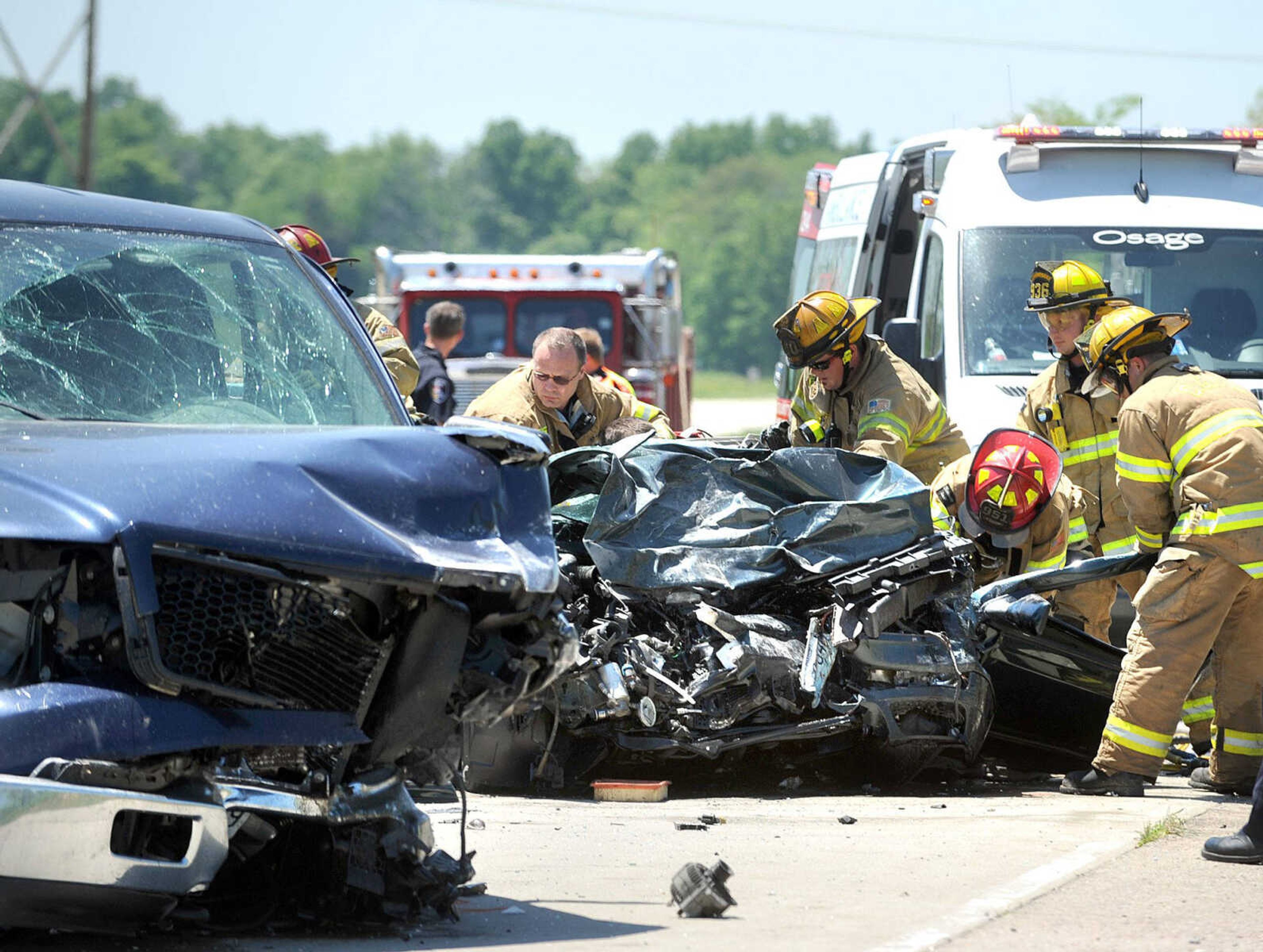 Members of the Cape Girardeau Fire Department work to extricate a man from a Volkswagen passenger car Tuesday after it collided with a Ford pickup truck on LaSalle Avenue just west of Route W. Alex P. Hodges, 20, was killed in the crash. (Laura Simon)