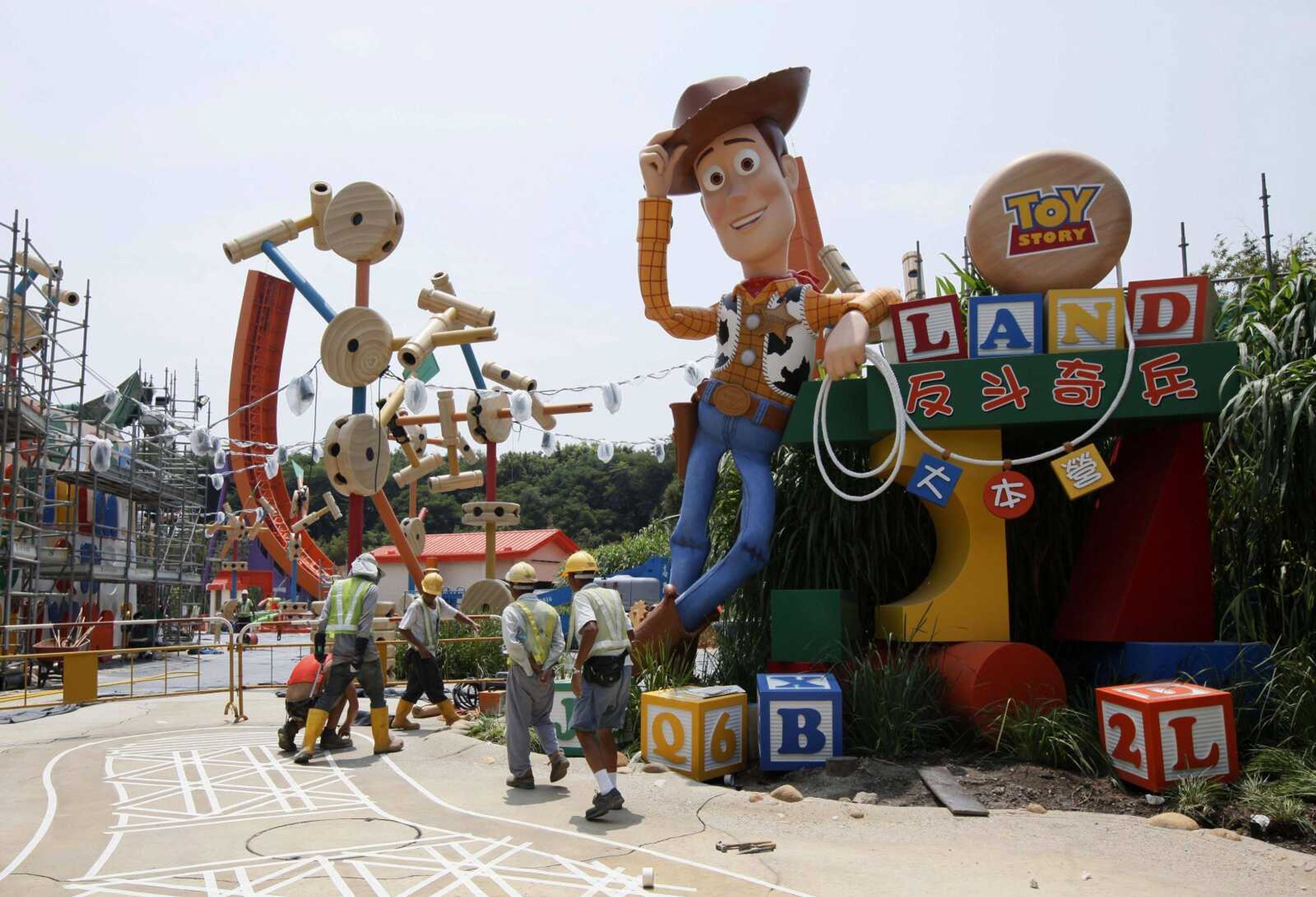 In this Sept. 8, 2011, file photo, workers walk past "Toy Story" character Woody at the construction site of the new attraction area Toy Story Land in Hong Kong Disneyland. A new 11-acre Toy Story Land is planned for Walt Disney World Resort near Orlando, Florida, in 2018, opening at the theme park's Hollywood Studios.