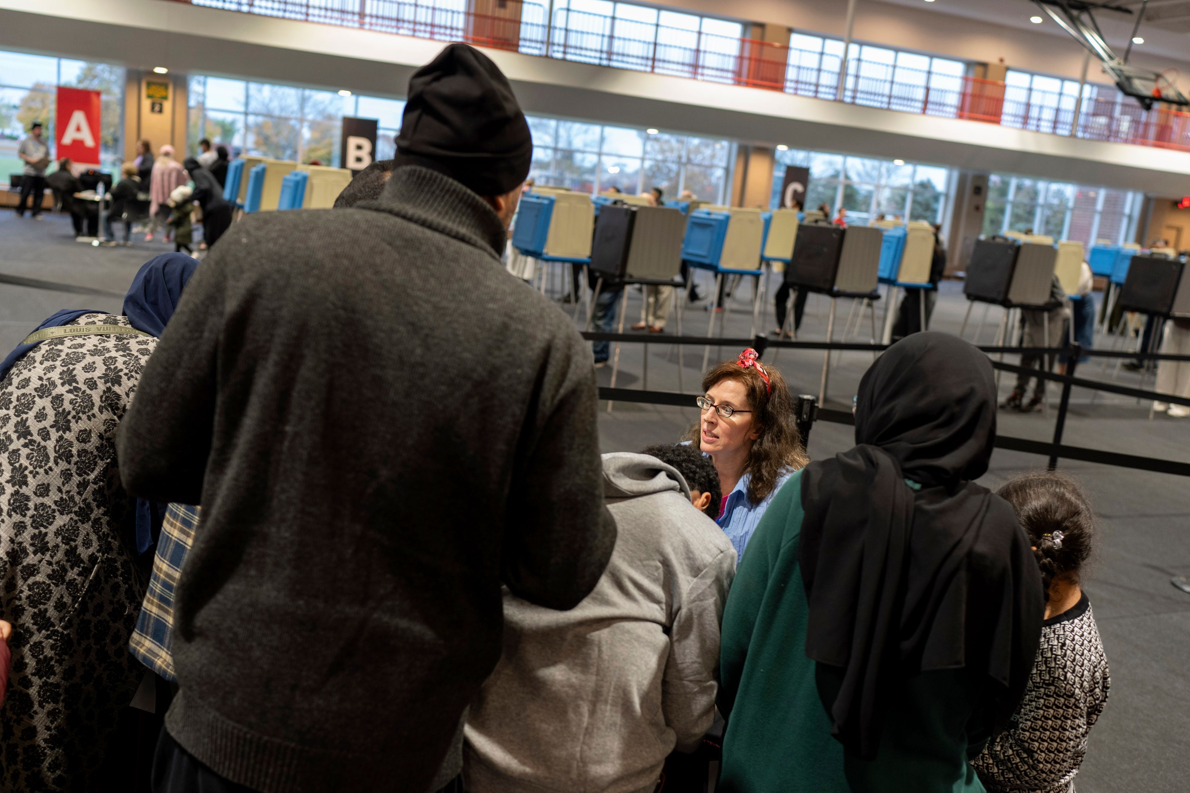 An election official helps check in voters at Ford Community and Performing Arts Center on the last day of early in-person voting, Sunday, Nov. 3, 2024, in Dearborn, Mich., the nation's largest Arab-majority city. (AP Photo/David Goldman)