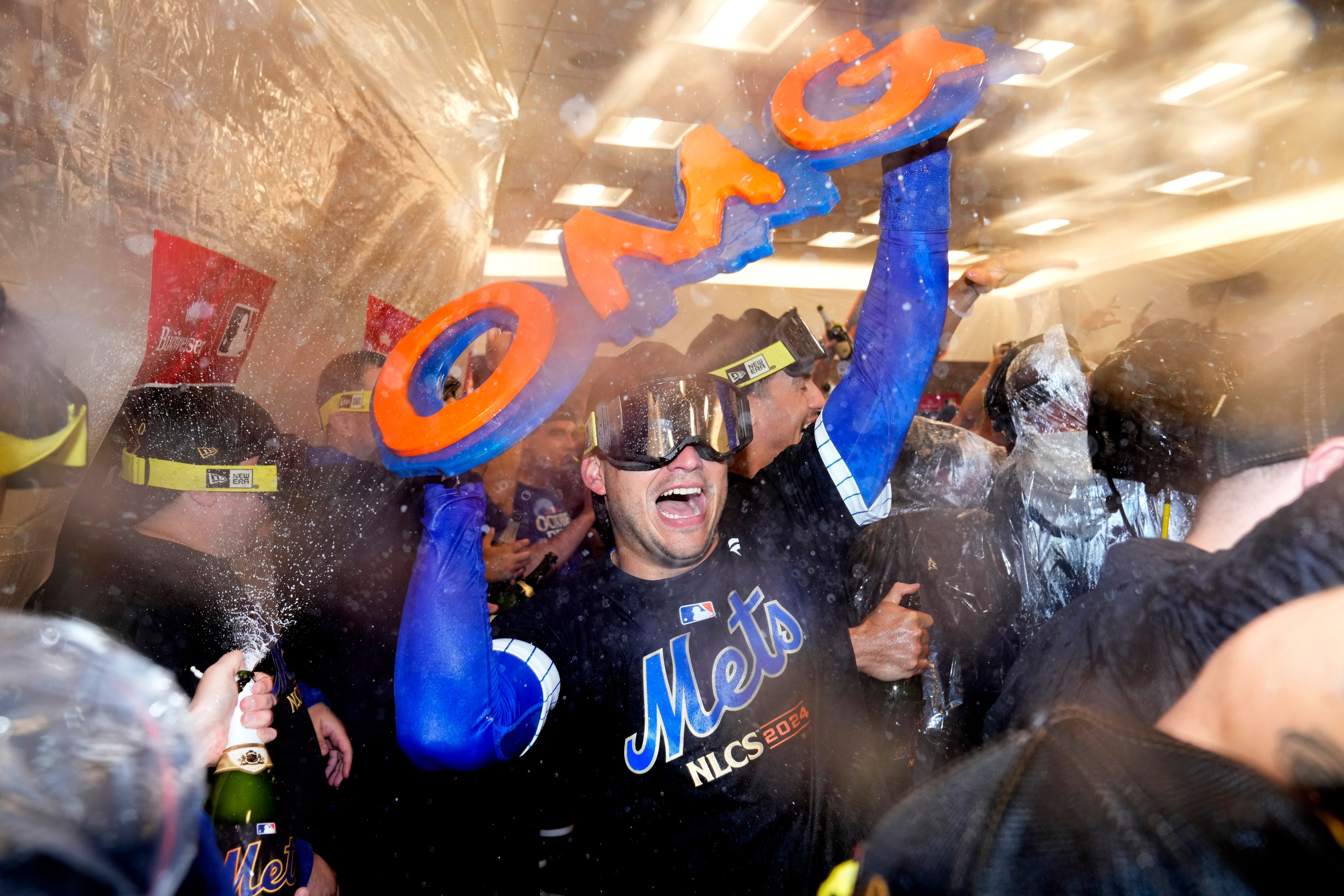 The New York Mets celebrate in the locker room after defeating the Philadelphia Phillies in Game 4 of the National League baseball playoff series, Wednesday, Oct. 9, 2024, in New York. (AP Photo/Frank Franklin II)