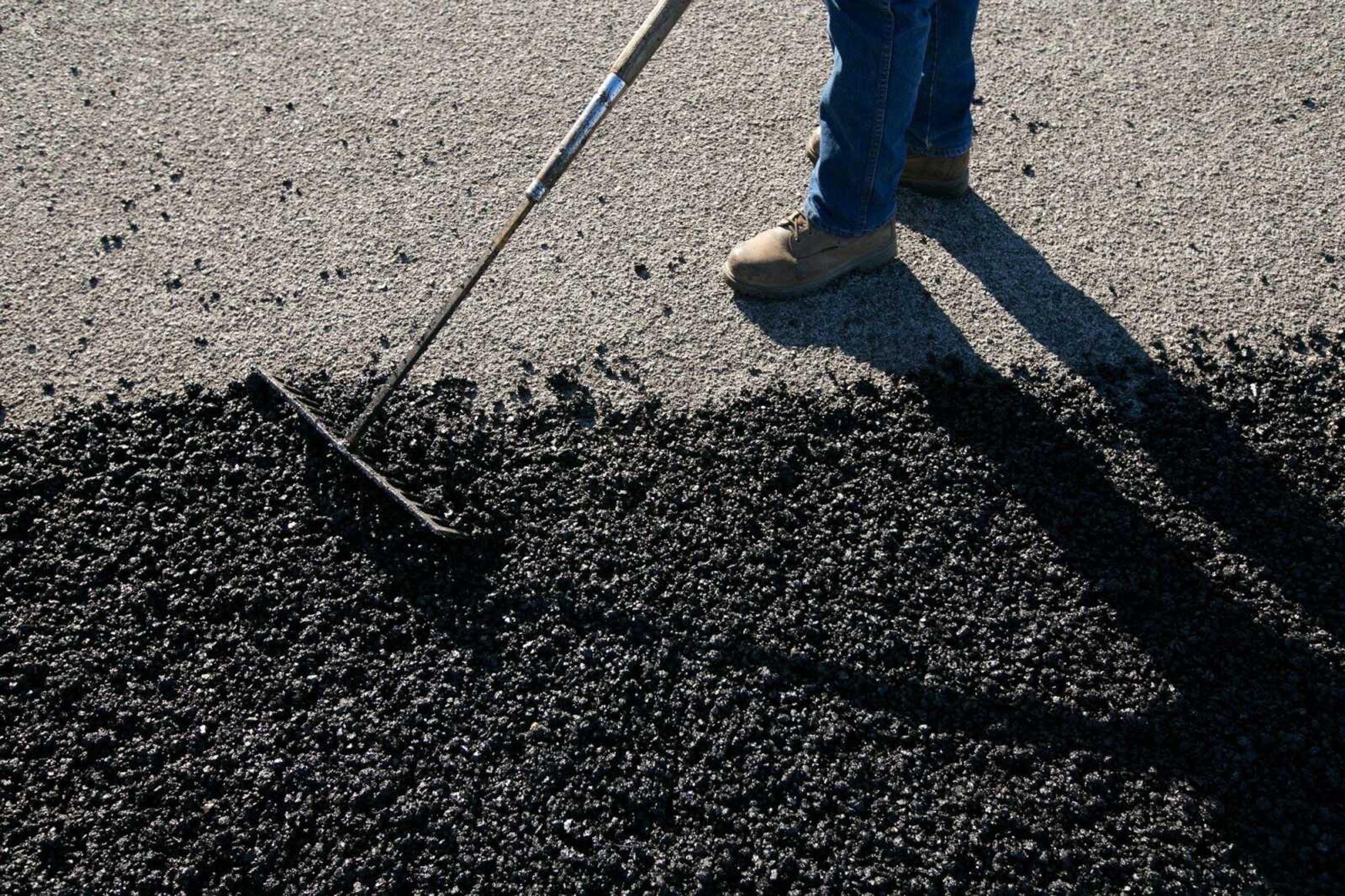 Michael Shovan, part of a road maintenance crew for the Cape Special Road District, repairs a pothole Friday along County Road 651. (Glenn Landberg)