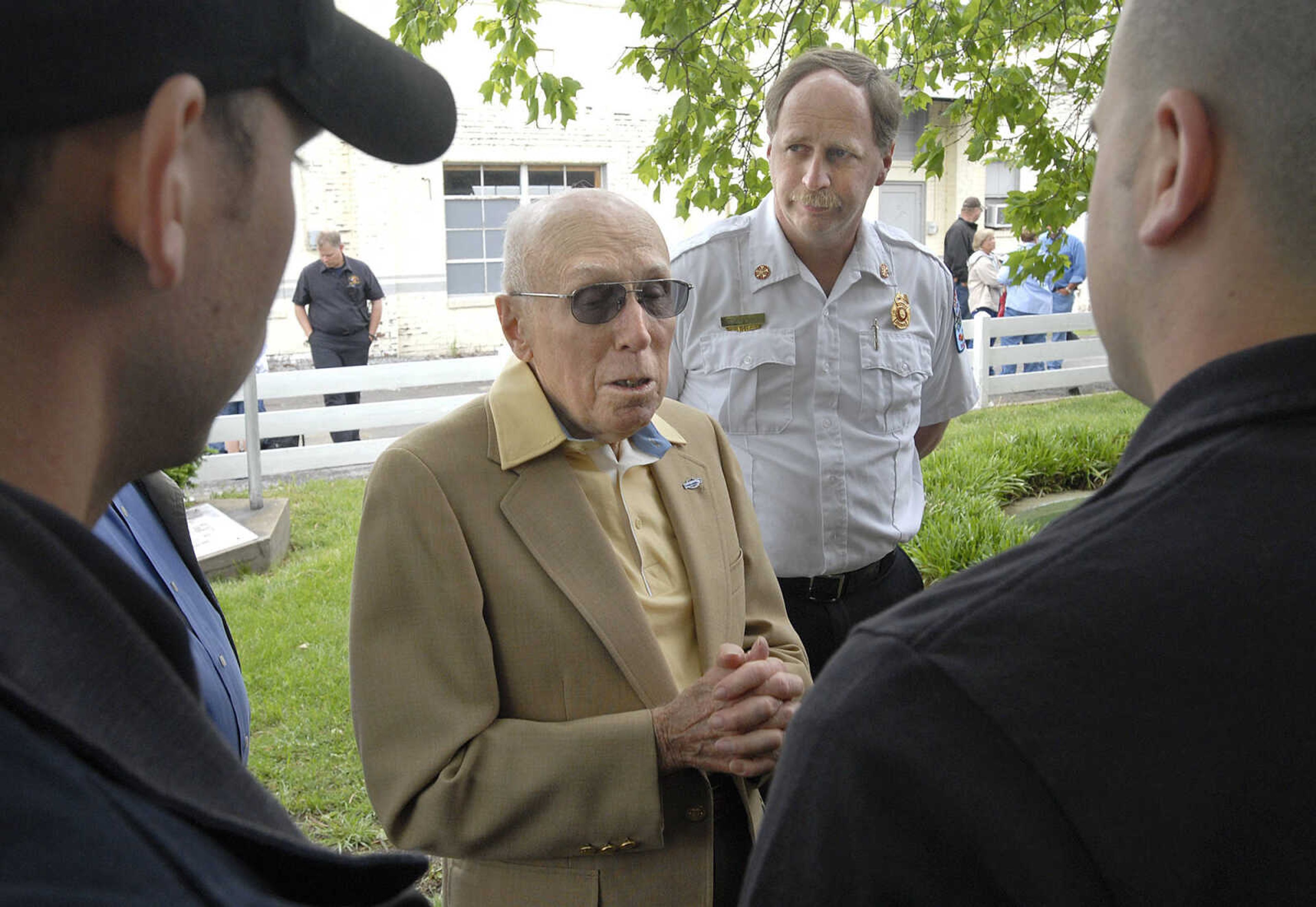 Fred Kraft of Cape Girardeau, son of Barney Kraft, Cape Girardeau's first paid fire chief, talks with firefighters outside the Cape River Heritage Museum, the old Fire Station No. 1, Saturday during the Cape Girardeau Fire Department's 100th year anniversary celebration. Behind him is current fire chief Rick Ennis. Kraft said his father received $65 a month along with room and board.