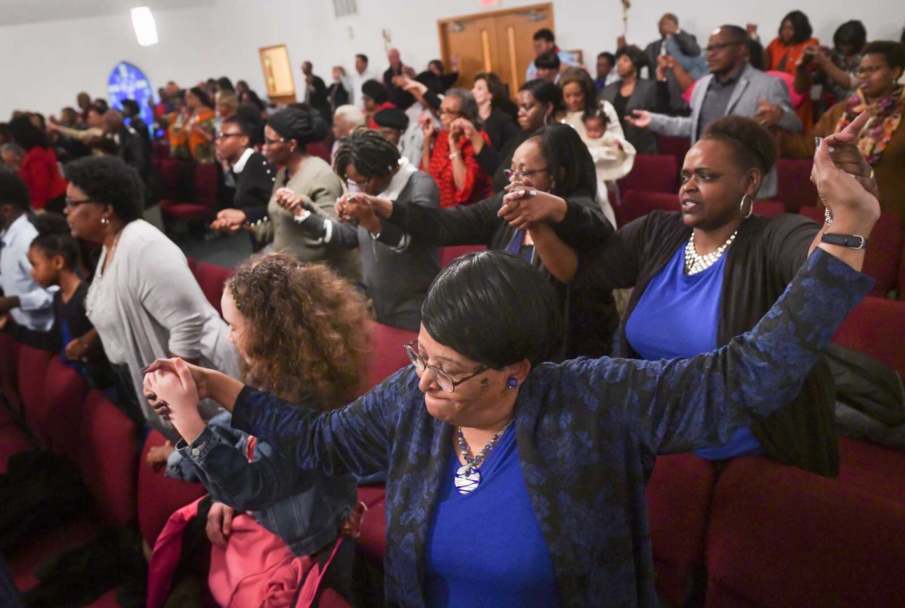 True Vine Ministries member Janice Davis, lower center, holds hands with 12-year-old Jasmine Pettigrew, left, and Fredreka Green during a closing prayer at a multi-church Sunday celebration coordinated by the Pastoral Assembly of Cape Girardeau on Feb. 23, 2020, at Second Missionary Baptist Church in Cape Girardeau. The  president and vice-president of the recently-formed local pastoral assembly, Rev. William "Tiger" Bird Jr. and Rev. Adrian Taylor Jr., delivered speeches at the celebration calling community members to unify by connecting with one another and moving into action.