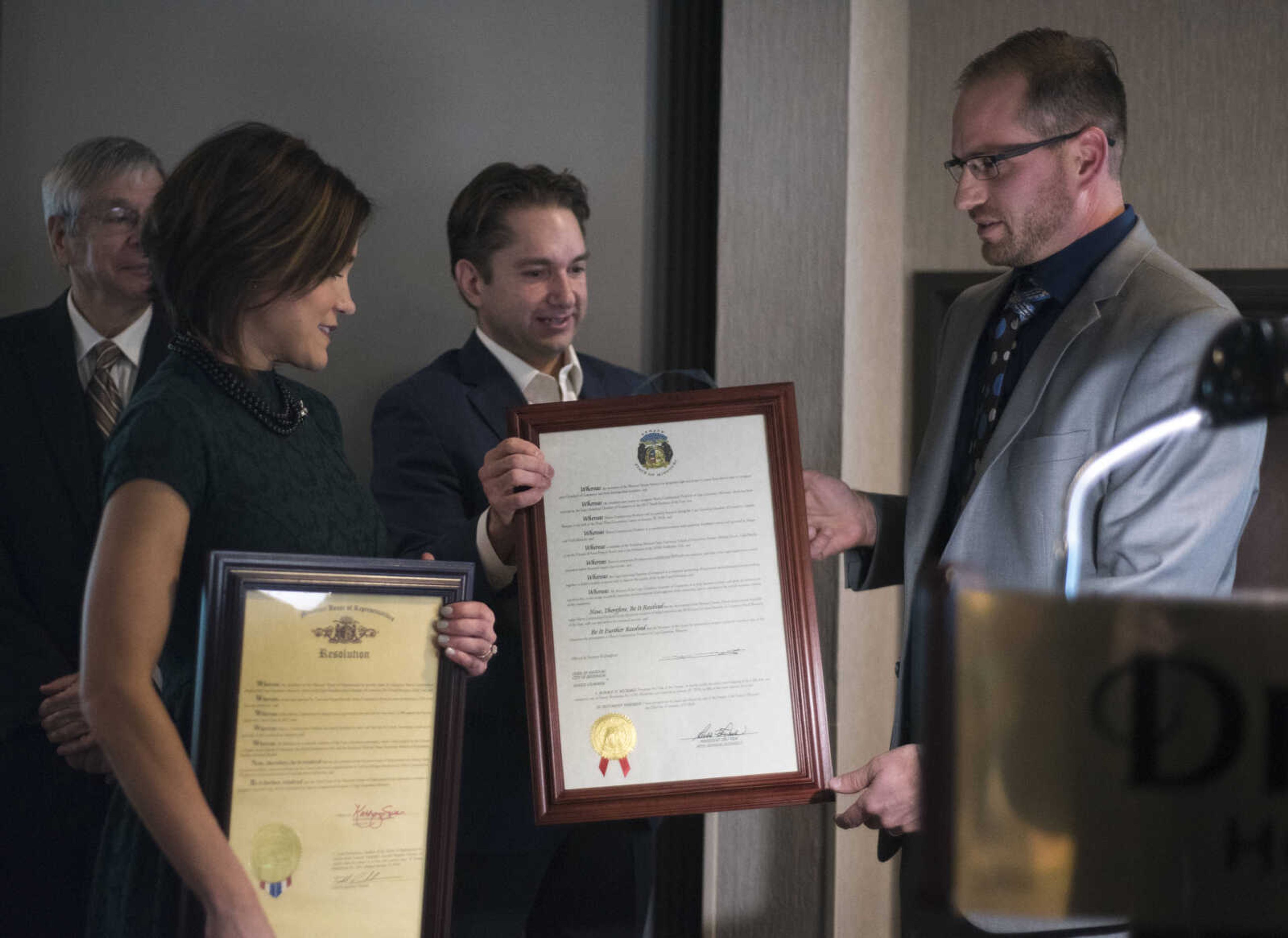 Jon K. Rust, outgoing chairman of the chamber board, center, presents the Small Business of the Year award to Megan, left, and Todd Marchi of Marco Construction at the Cape Girardeau Area Chamber of Commerce's annual dinner held Jan. 26, 2018, at the Drury Plaza Conference Center in Cape Girardeau.