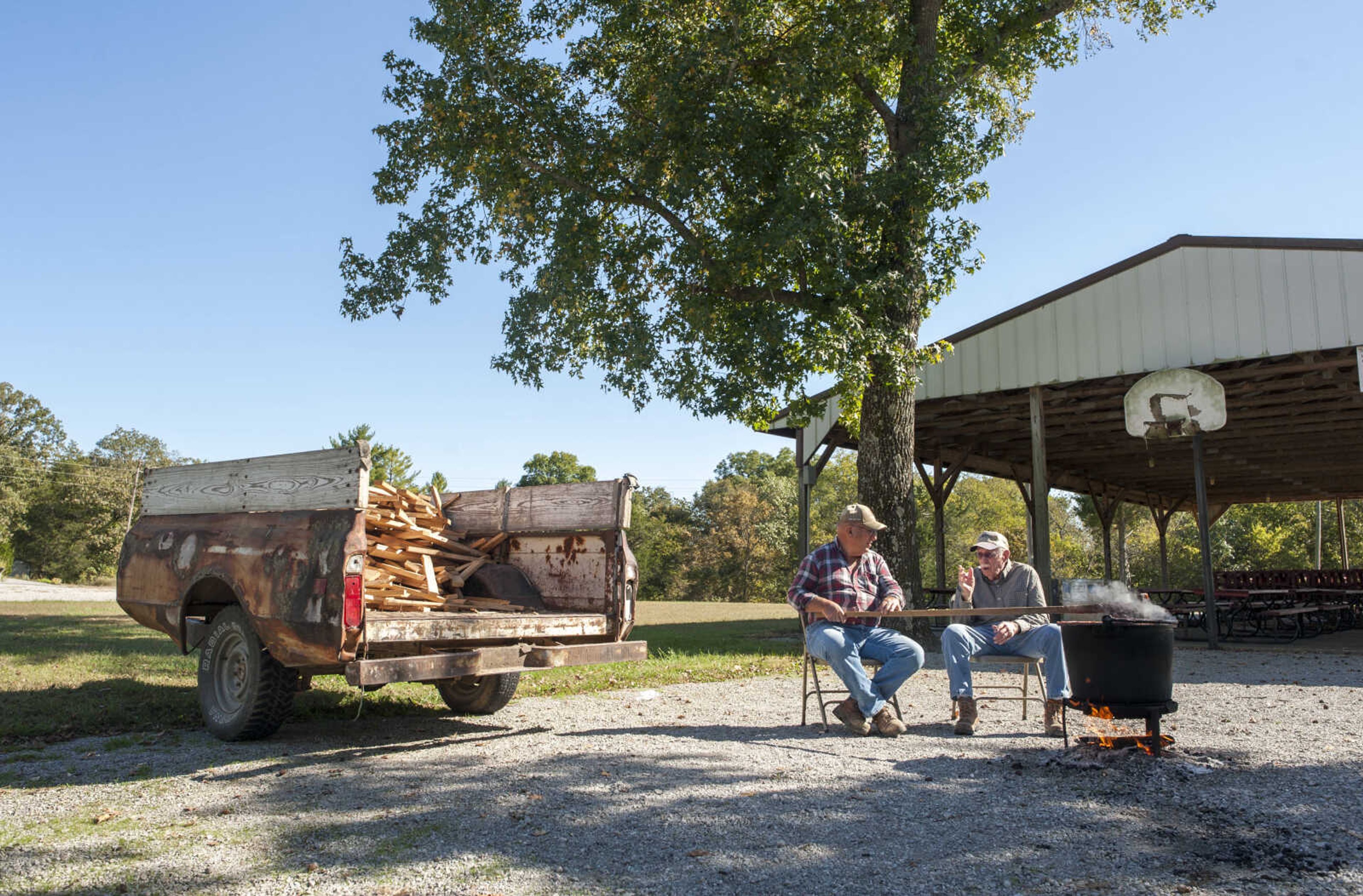 Clarenze Meyer, center right, talks to Herman Erzfeld, far right, while stirring a kettle of apple butter Monday, Oct. 14, 2019, at St. Joseph Catholic Church in Apple Creek, Missouri. Published in the Southeast Missourian's November TBY section.