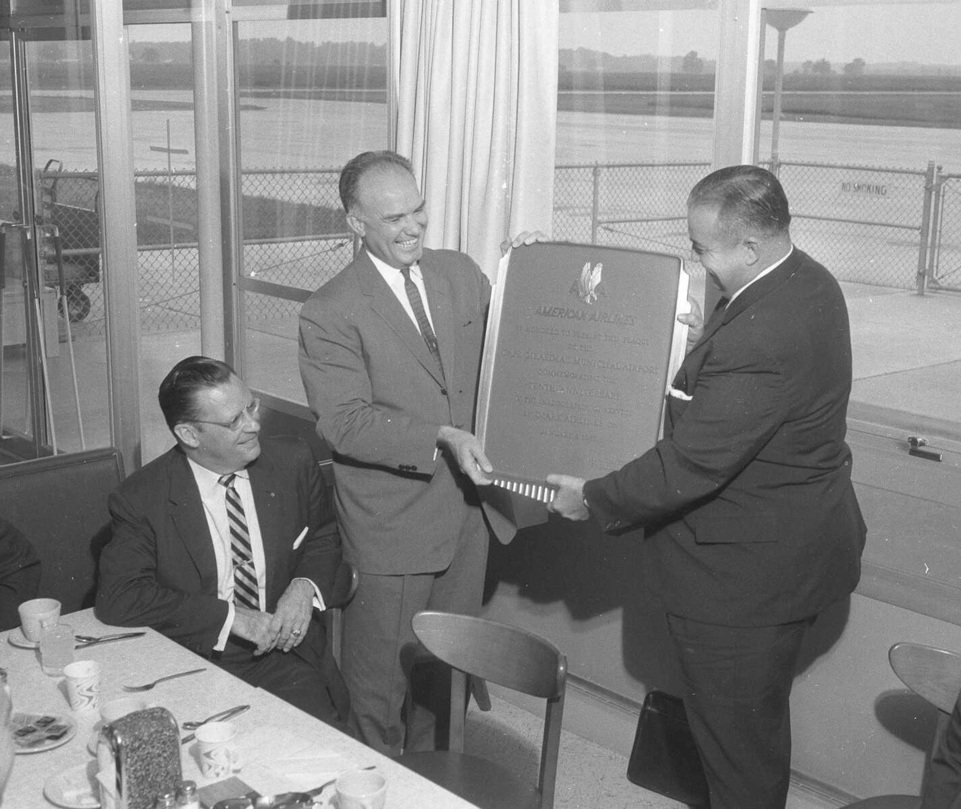 An plaque commemorating Ozark Airline's 10 years of service in Cape Giirardeau was given to the city in 1961. Paul Rodgers of Ozark, seated left, looked on as American Airlines representative Gene Abney, center, presented the plaque to Rush Limbaugh Jr., of the city airport board. (Missourian archives photo by G.D. "Frony" Fronabarger)