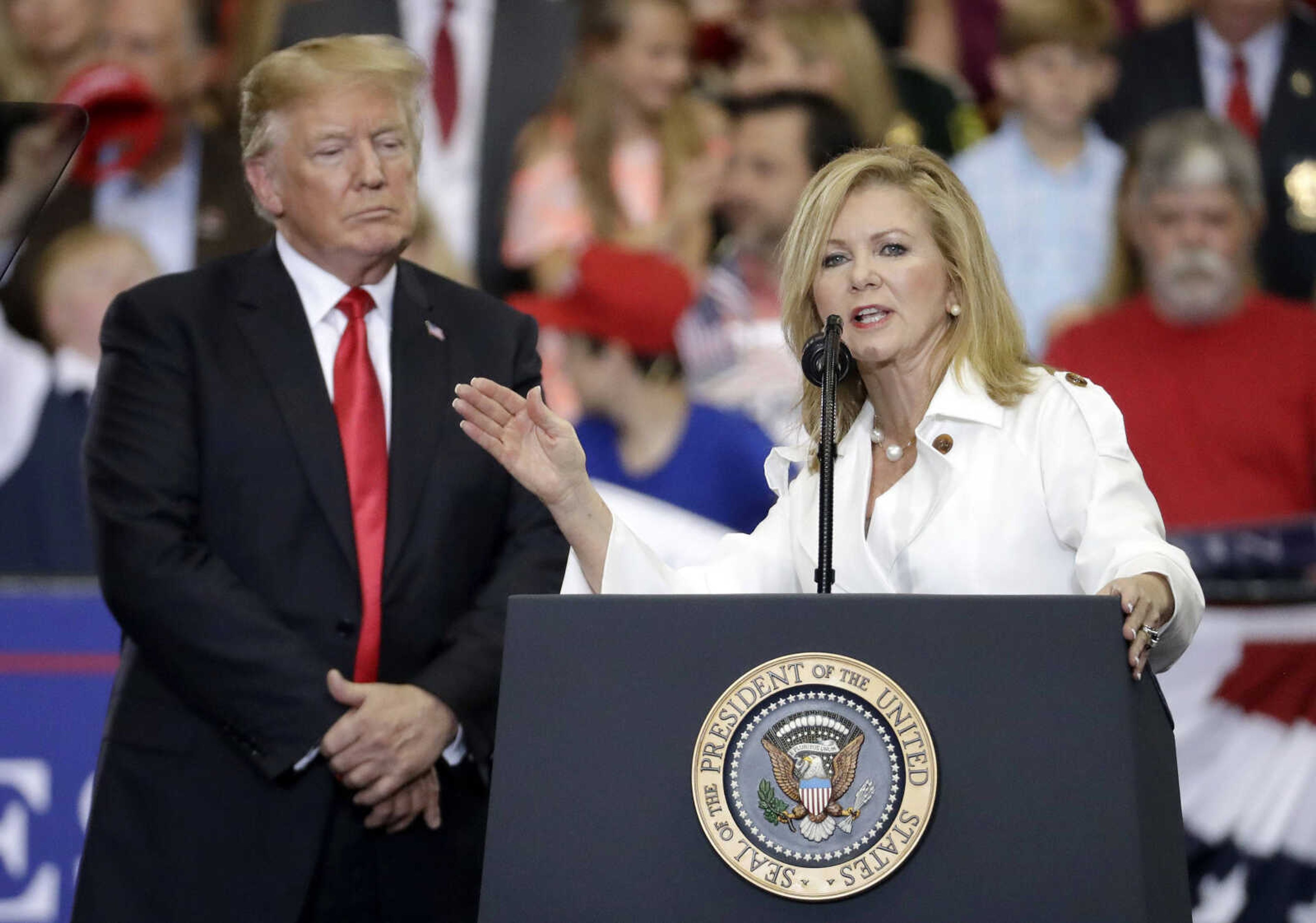 President Donald Trump listens as Rep. Marsha Blackburn, R-Tenn., speaks May 29 at a rally in Nashville, Tennessee.