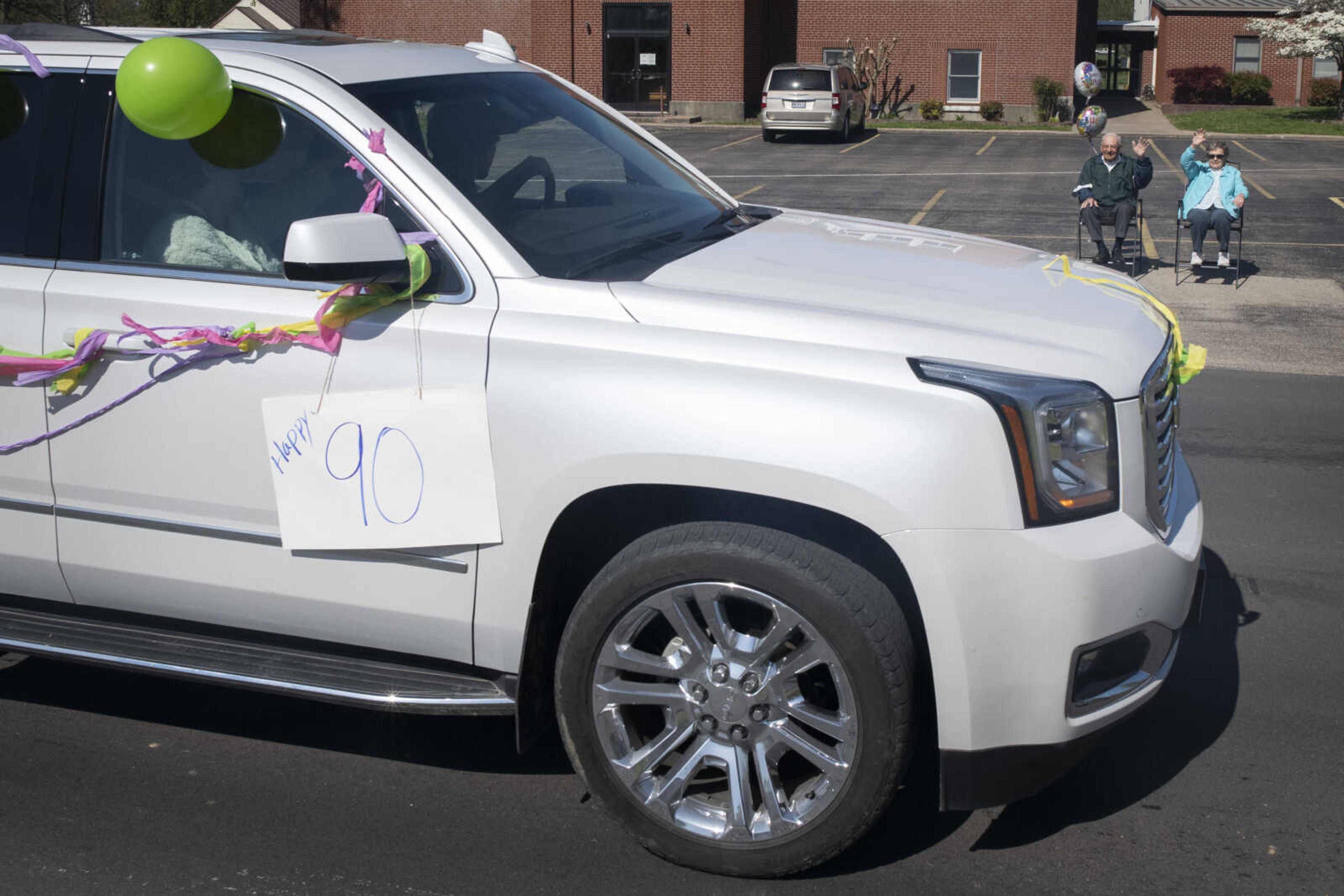 On his 90th birthday, Paul L. Essner of Benton, Missouri, and his wife Bert Essner wave to people passing in a parade celebrating Paul's birthday Saturday, April 18, 2020, outside St. Denis Catholic School in Benton, Missouri.