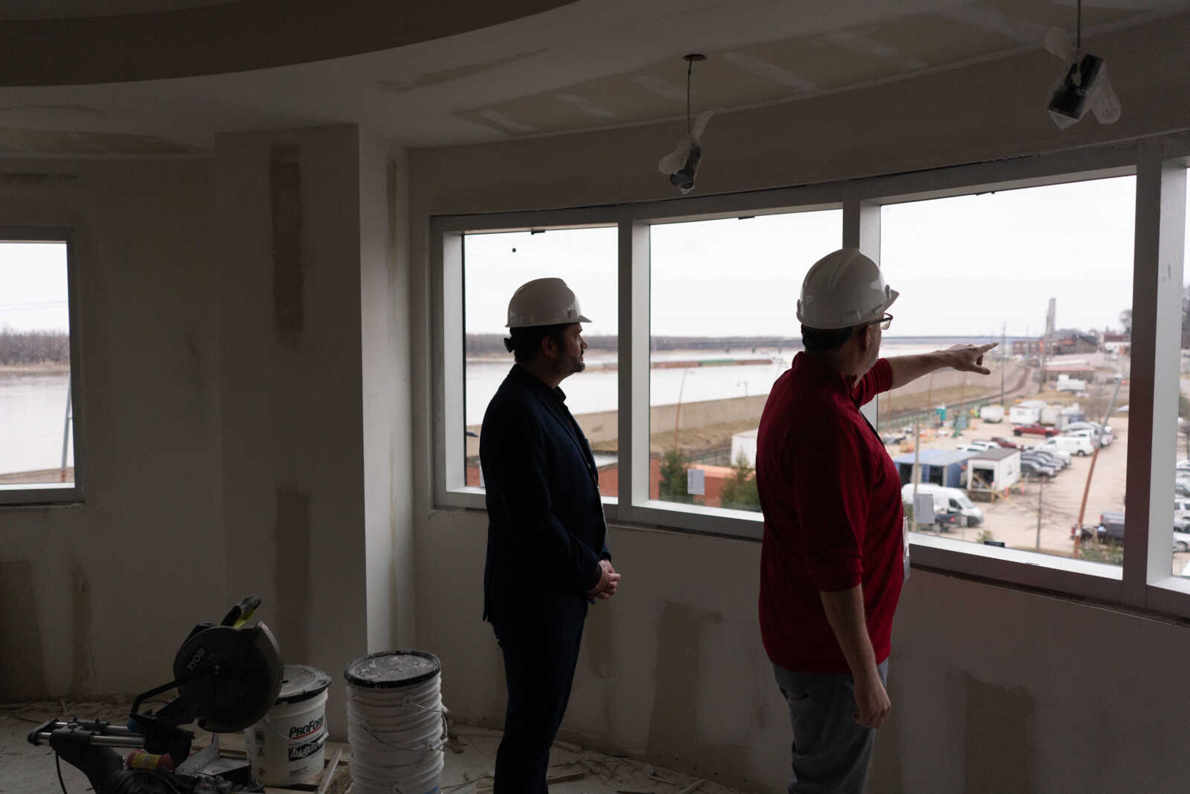 Lyle Randolph and Loren Ramirez are pictured in The Riverview by Century Casino, slated for a grand opening the weekend before the eclipse. In the top right photo, Randolph walks down what will be the premier entrance to Beacon 53. In the bottom photo, Randolph points out points of interest in the view from a circular suite.