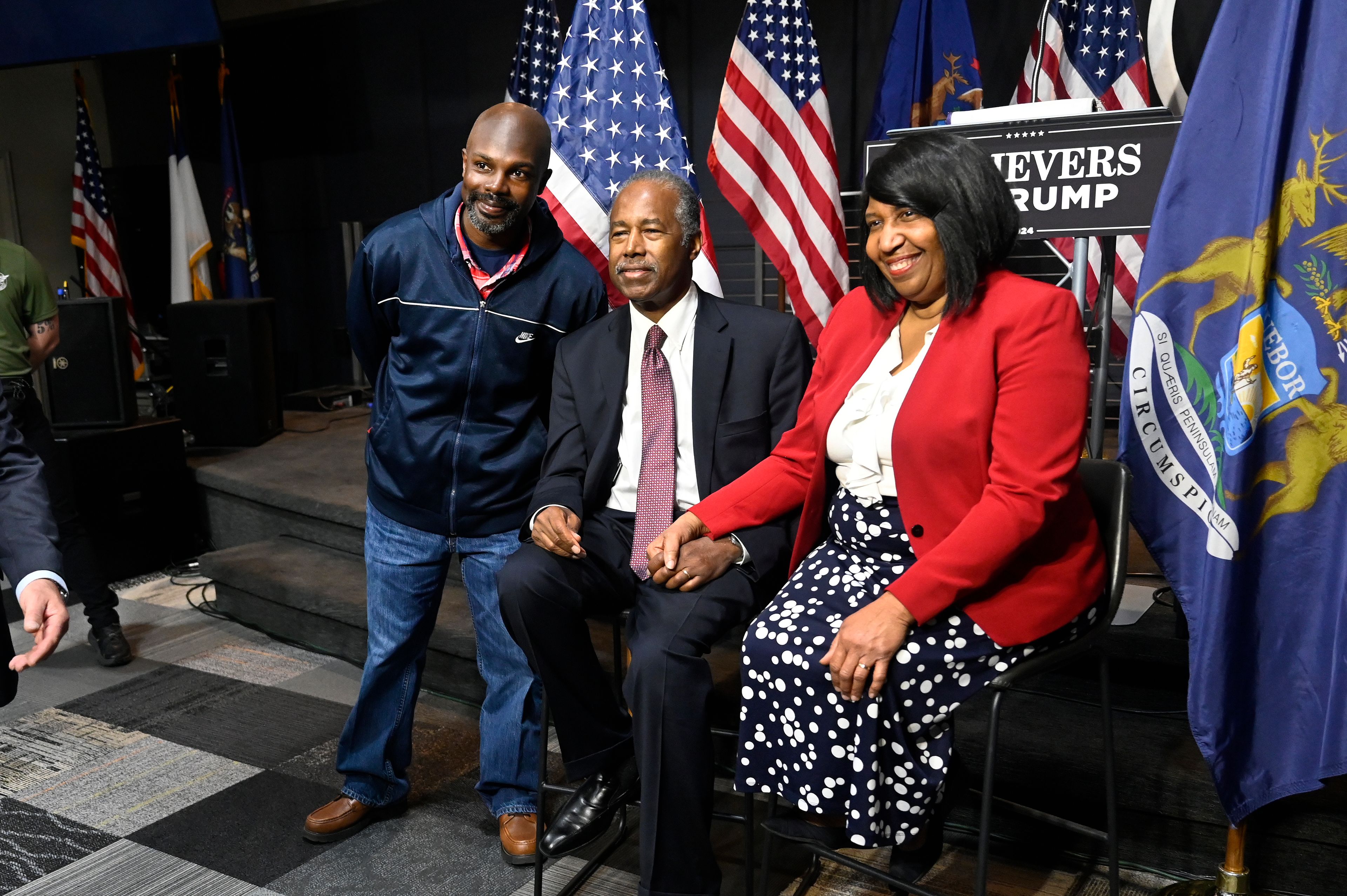 Ben Carson, center, and his wife Candy Carson, right, pose for a photo with Javon Wells following Carson's address to supporters of Republican presidential nominee former President Donald Trump, Saturday, Oct. 5, 2024, in Livonia, Mich. (AP Photo/Jose Juarez)