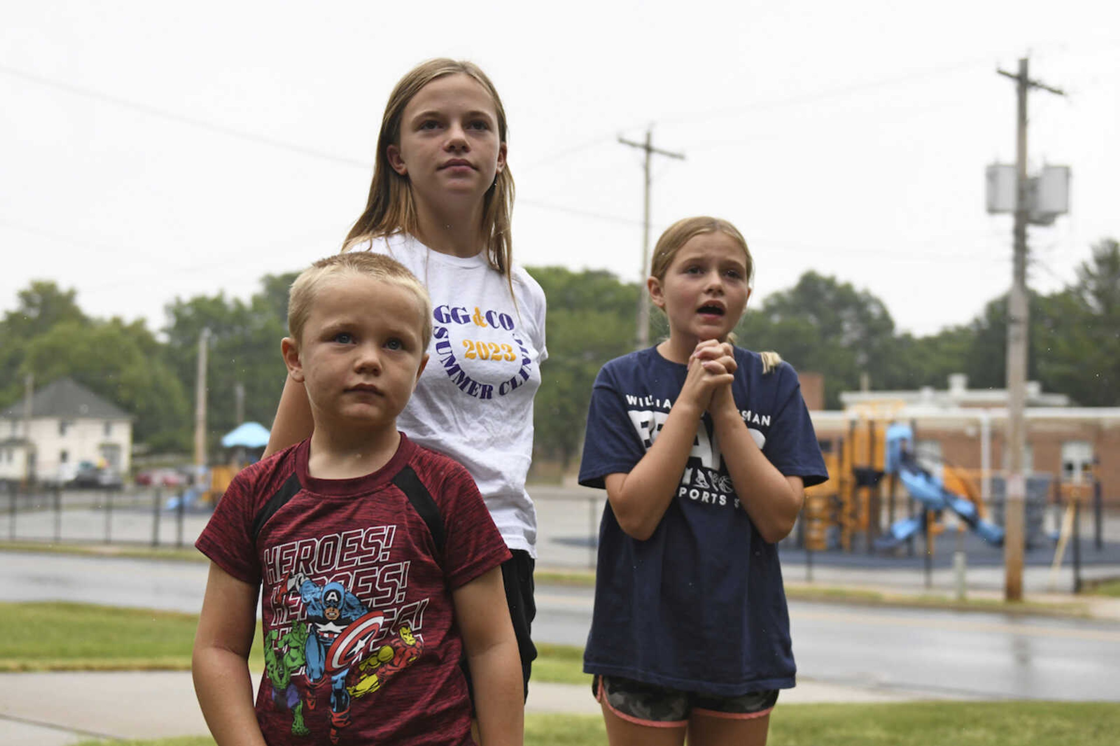 Hudson, 7, left, Callahan, 13, middle, and Keegan Pruente, 10, right, stand outside their school on their first Monday home during the new four-day school week Sept. 11 in Independence, Missouri. Hundreds of school systems around the country have adopted four-day weeks in recent years, mostly in rural and western parts of the U.S. Districts cite cost savings and advantages for teacher recruitment. Still, some experts question the effects on students who already missed out on significant learning during the pandemic.