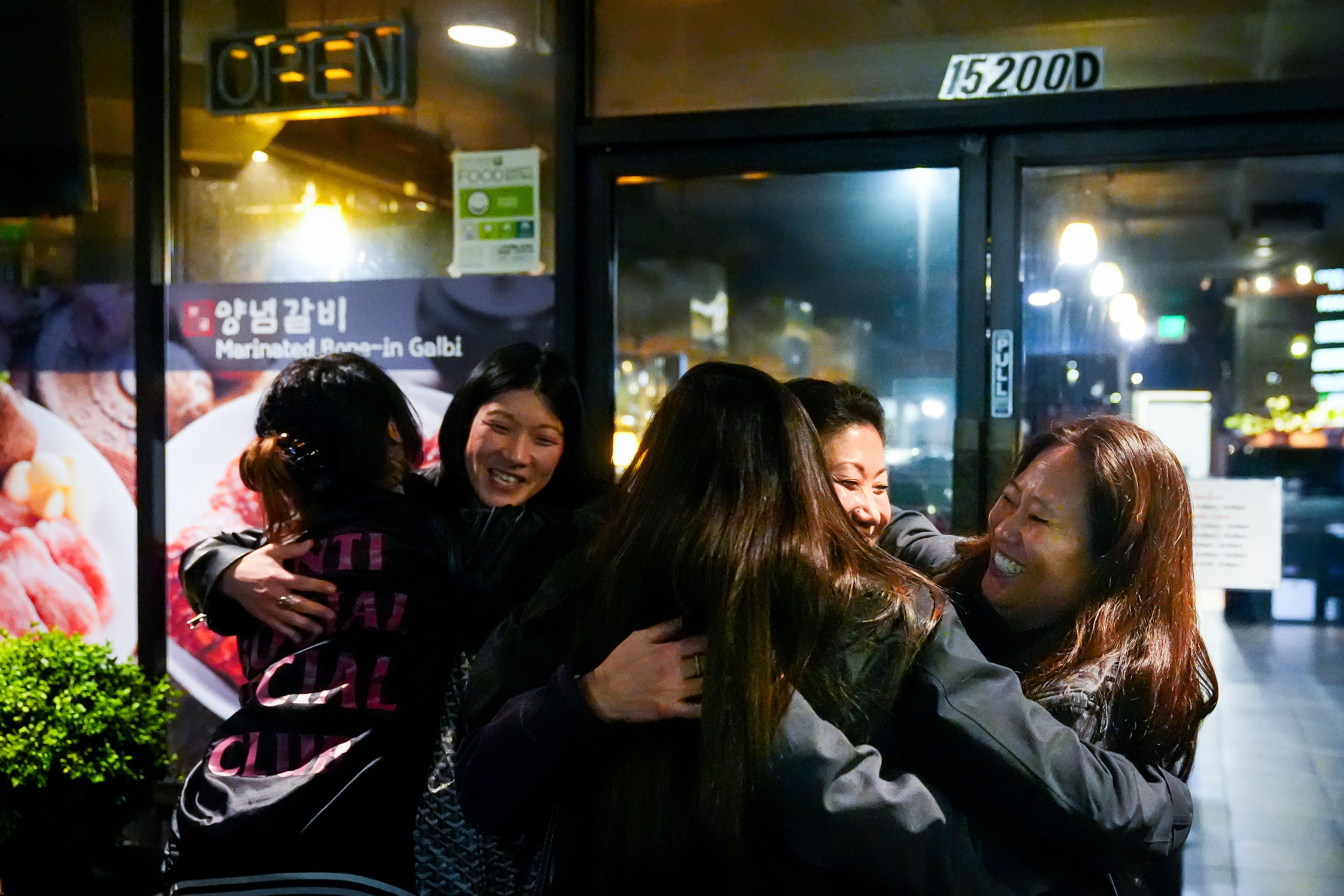 Korean adoptee Rebecca Kimmel, right, hugs Michelle Leco, center, and Jenny Kelly, left, after leaving dinner at Yetgol Old Village Korean BBQ with fellow adoptees, Sunday, Jan. 28, 2024, in Seattle. The Korean adoptee diaspora is thought to be the largest in the world, with thousands returning to South Korea in recent years to look for their birth families. (AP Photo/Lindsey Wasson)