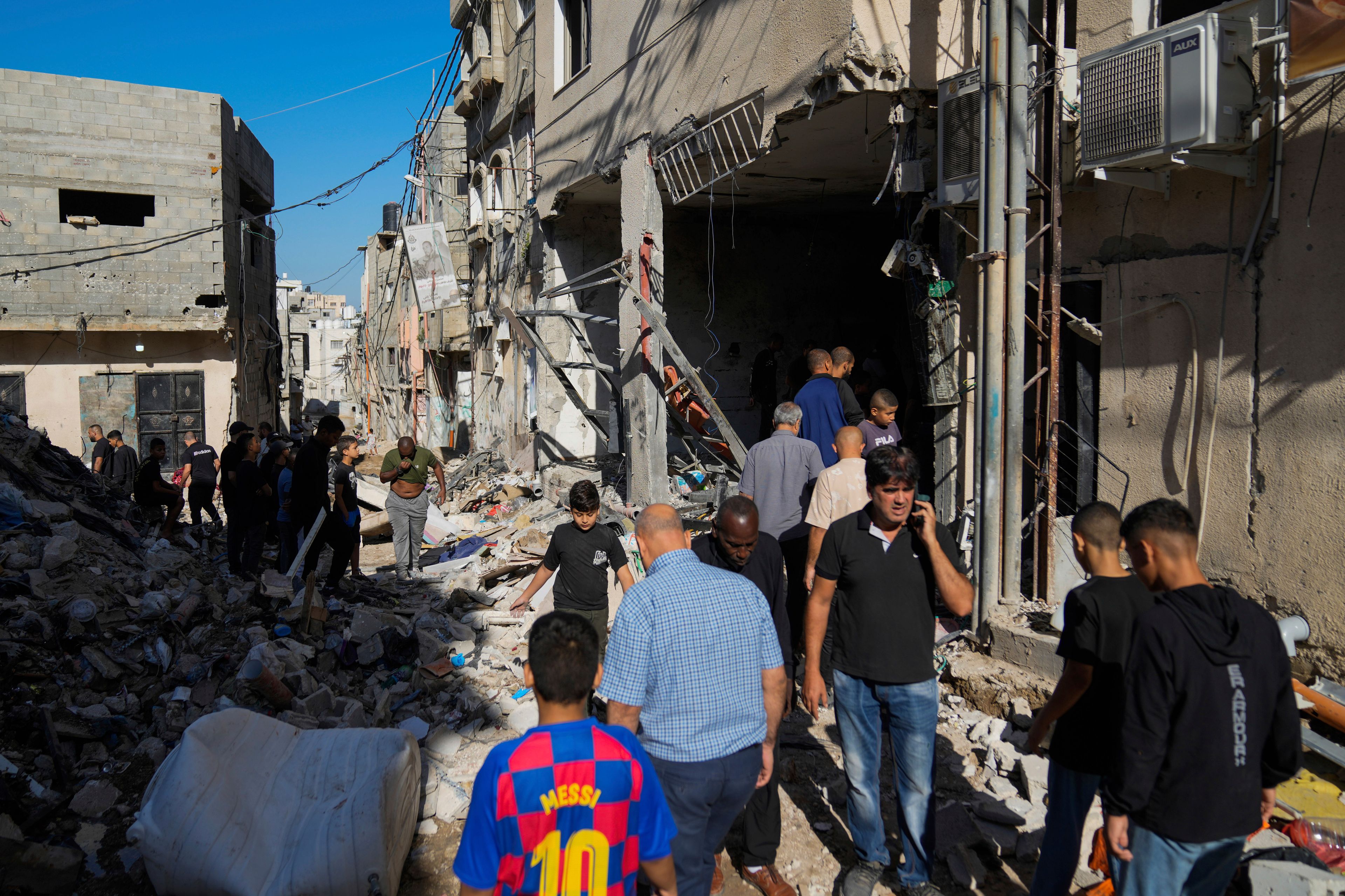 Palestinians examine the damage following an Israeli airstrike in the West Bank city of Tulkarem, which Palestinian health officials say killed 18 people and the Israeli military says took out a Hamas leader, on Friday, Oct. 4, 2024. (AP Photo/Nasser Nasser)