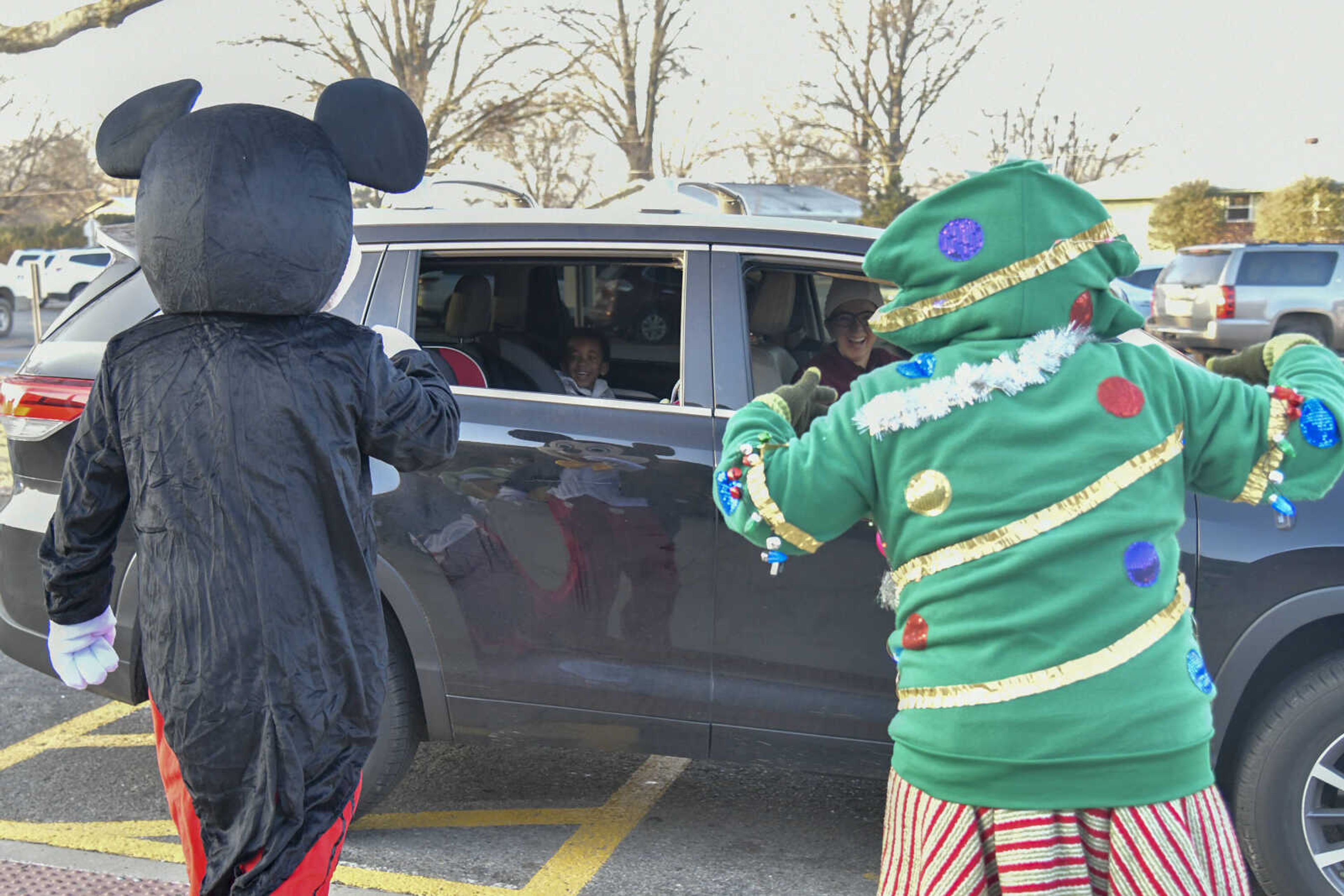 Assistant Superintendent Josh Crowell as Mickey Mouse and Psychological Examiner Stephanie Craft as a Christmas tree greet people in cars as they drive by after dropping off students at Alma Schrader Elementary School in Cape Girardeau on Thursday, Dec. 17, 2020.