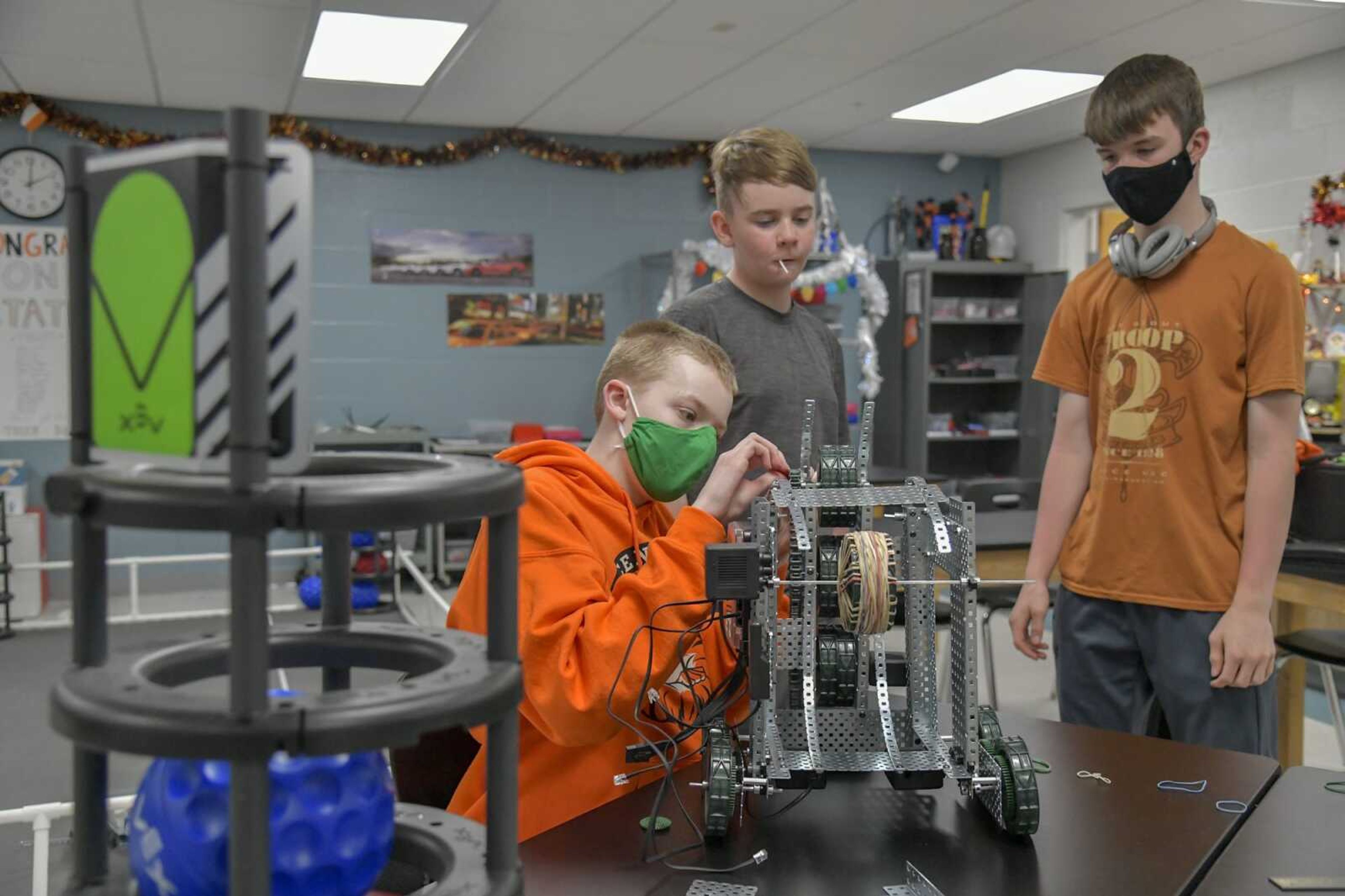 Students part of the TigerTech at Central Junior High, from left, Kelly Mattes, Hunter Jones and James Borders, assemble the robot that they plan to bring to the Missouri Middle School VEX State Championship this weekend on Monday, March 22, 2021. The aim for the robot to transfer balls from one goal to another, seen left.