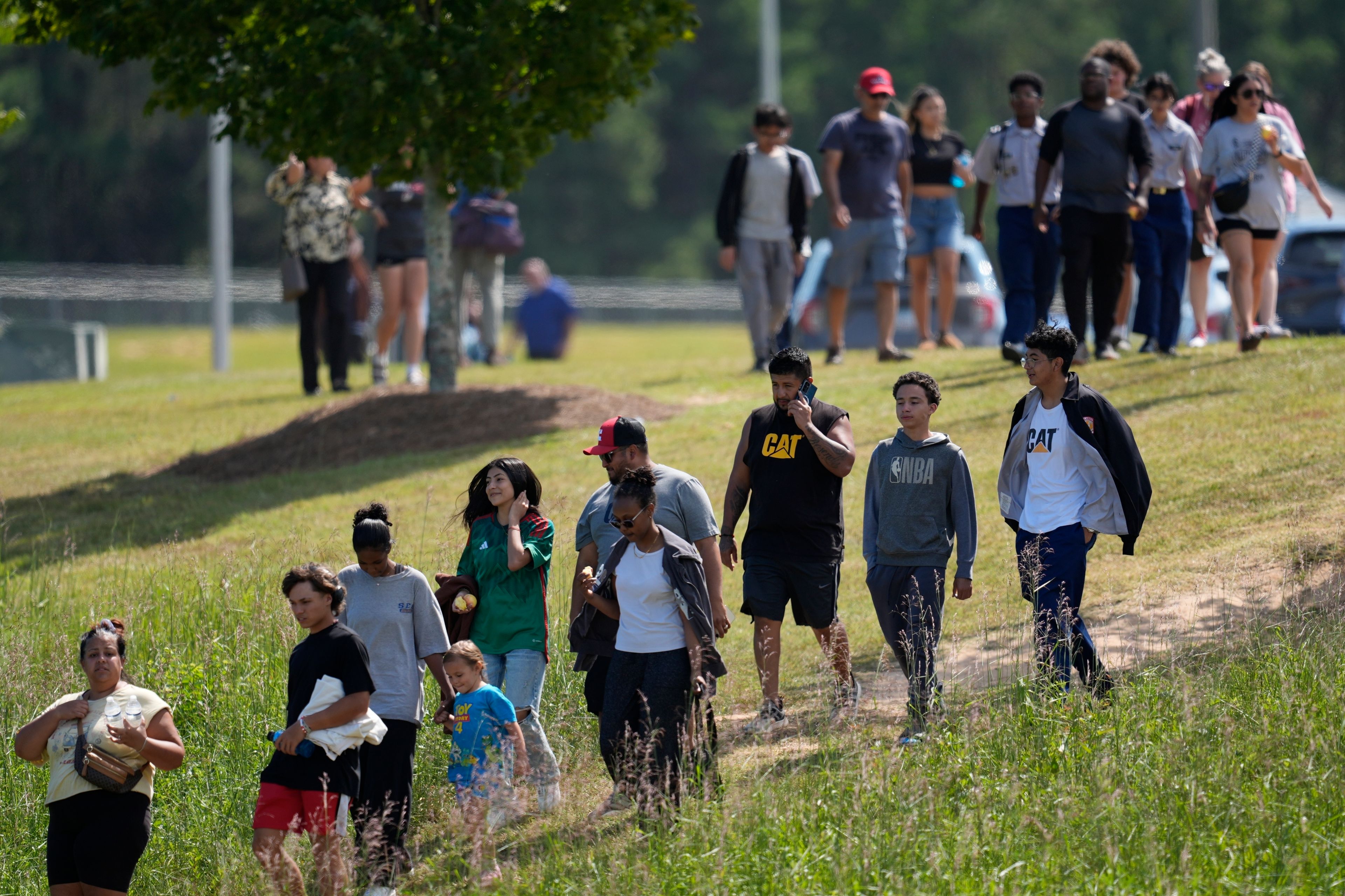 Students and parents walk off campus at Apalachee High School, Wednesday, Sept. 4, 2024, in Winder, Ga. (AP Photo/Mike Stewart)