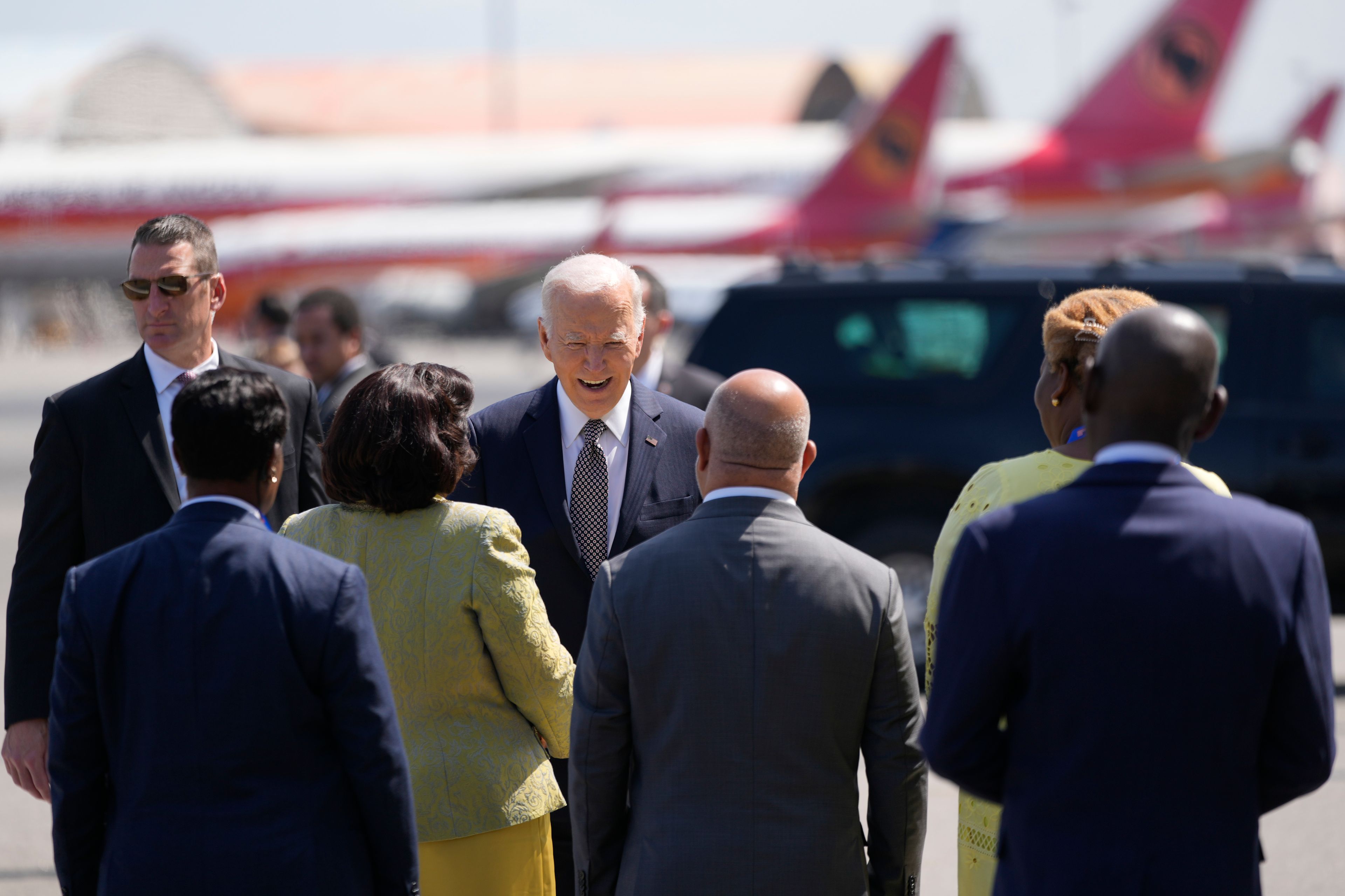 President Joe Biden talks to officials before boarding Air Force One at Quatro de Fevereiro International Airport in Luanda, Angola, on Wednesday, Dec. 4, 2024. (AP Photo/Ben Curtis)