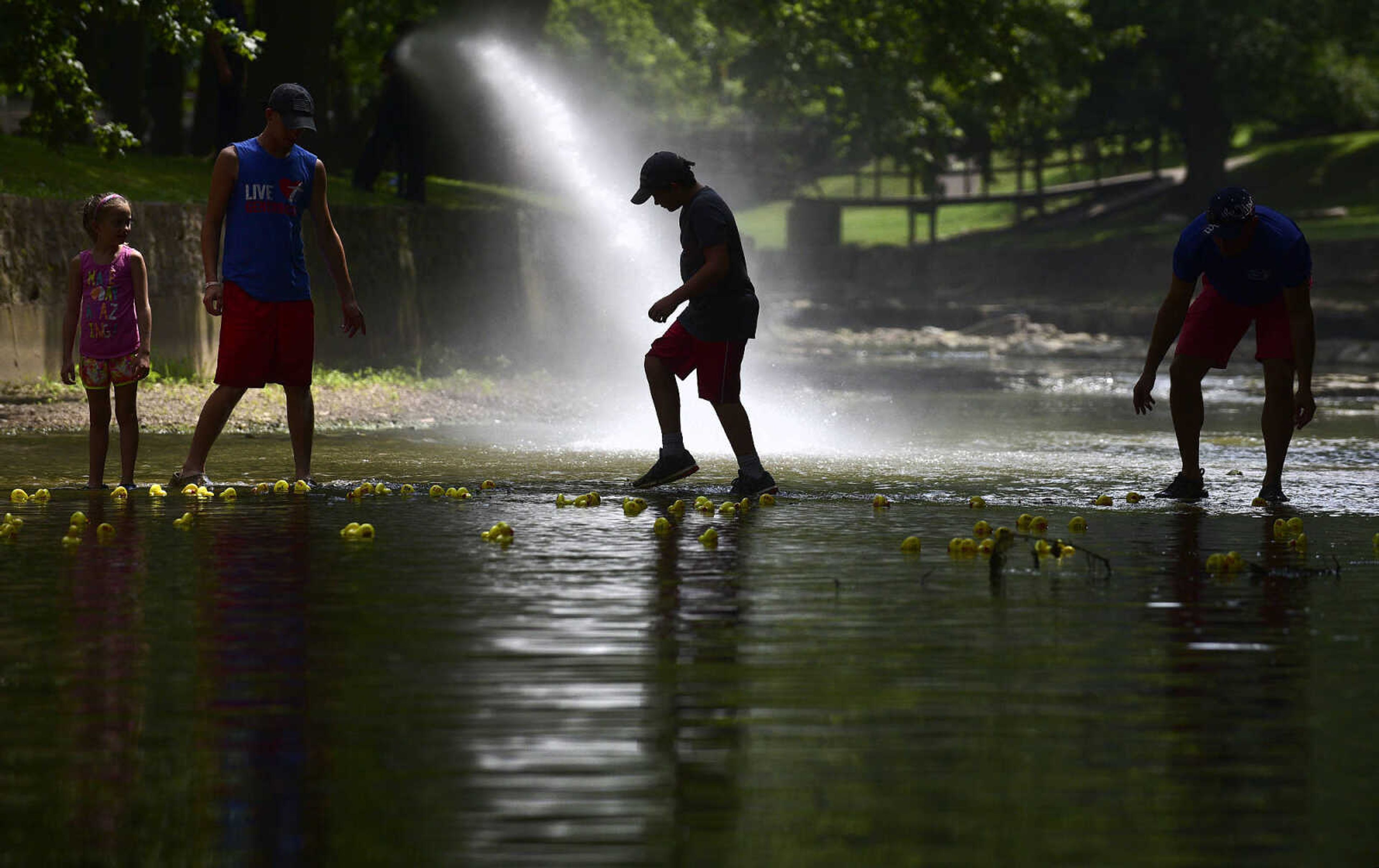 From left to right, Hannah Lichtenegger, Kaleb Kiefer, Garrett Lichtenegger and Matt Palich help guid the ducks down Hubble Creek during the duck race at the Fourth of July celebration on Tuesday at Jackson City Park.