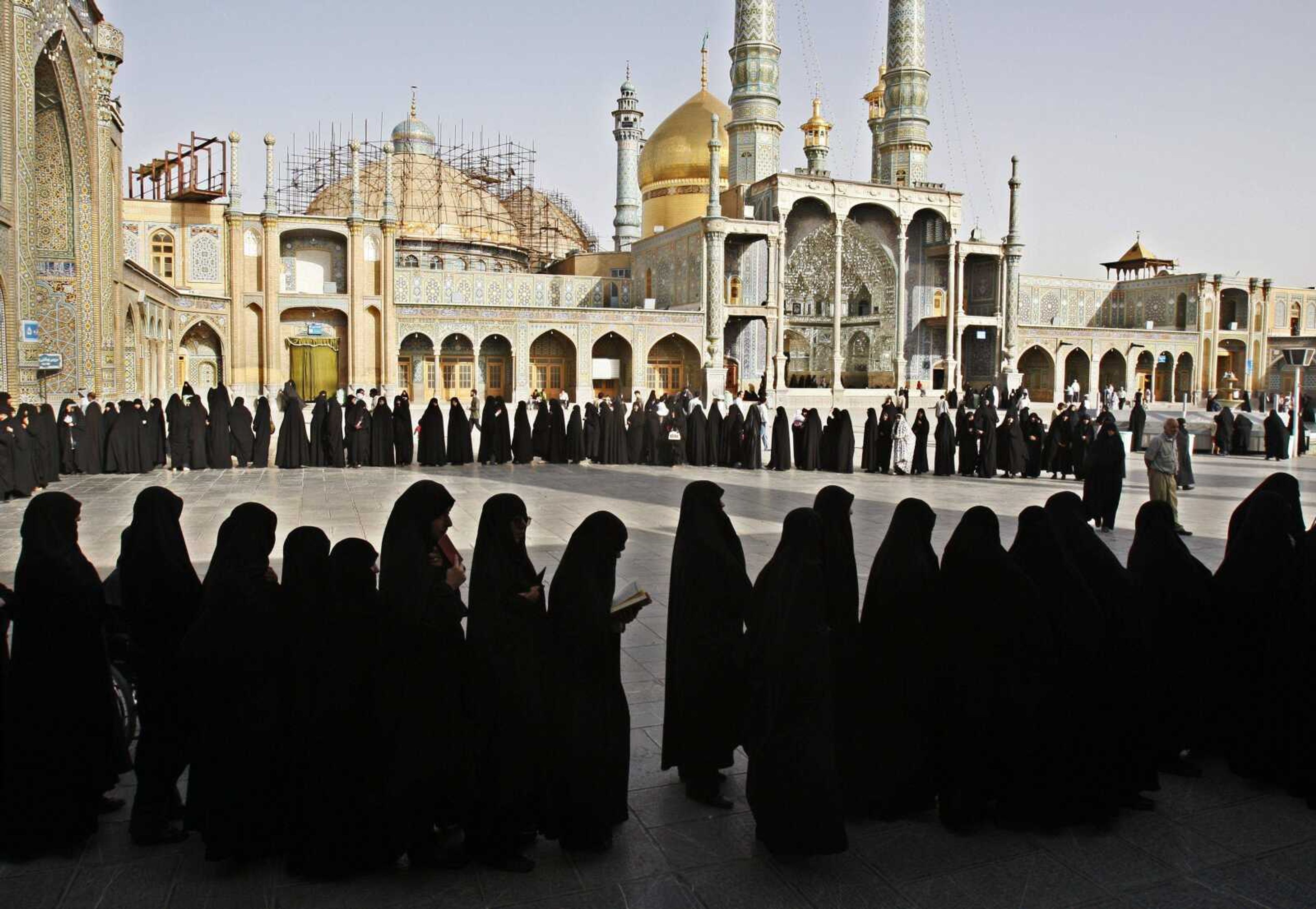 Iranian women stand in line to cast their votes at the Masoumeh shrine in Qum in Friday's presidential election. The election follows a hotly contested campaign pitting current president Mahmoud Ahmadinejad against leading challenger and reformist candidate Mir Hossein Mousavi, amongst others. (KAMRAN JEBREILI ~ Associated Press)