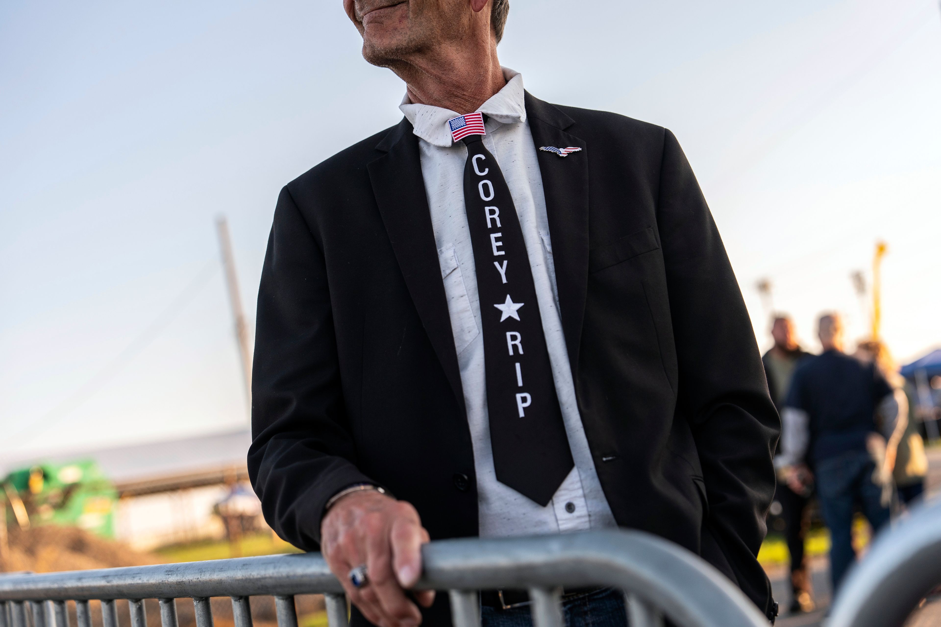 A supporter of Republican presidential nominee former President Donald Trump wears a tie honoring firefighter Corey Comperatore while waiting to enter a campaign rally at the Butler Farm Show, Saturday, Oct. 5, 2024, in Butler, Pa. (AP Photo/Julia Demaree Nikhinson)