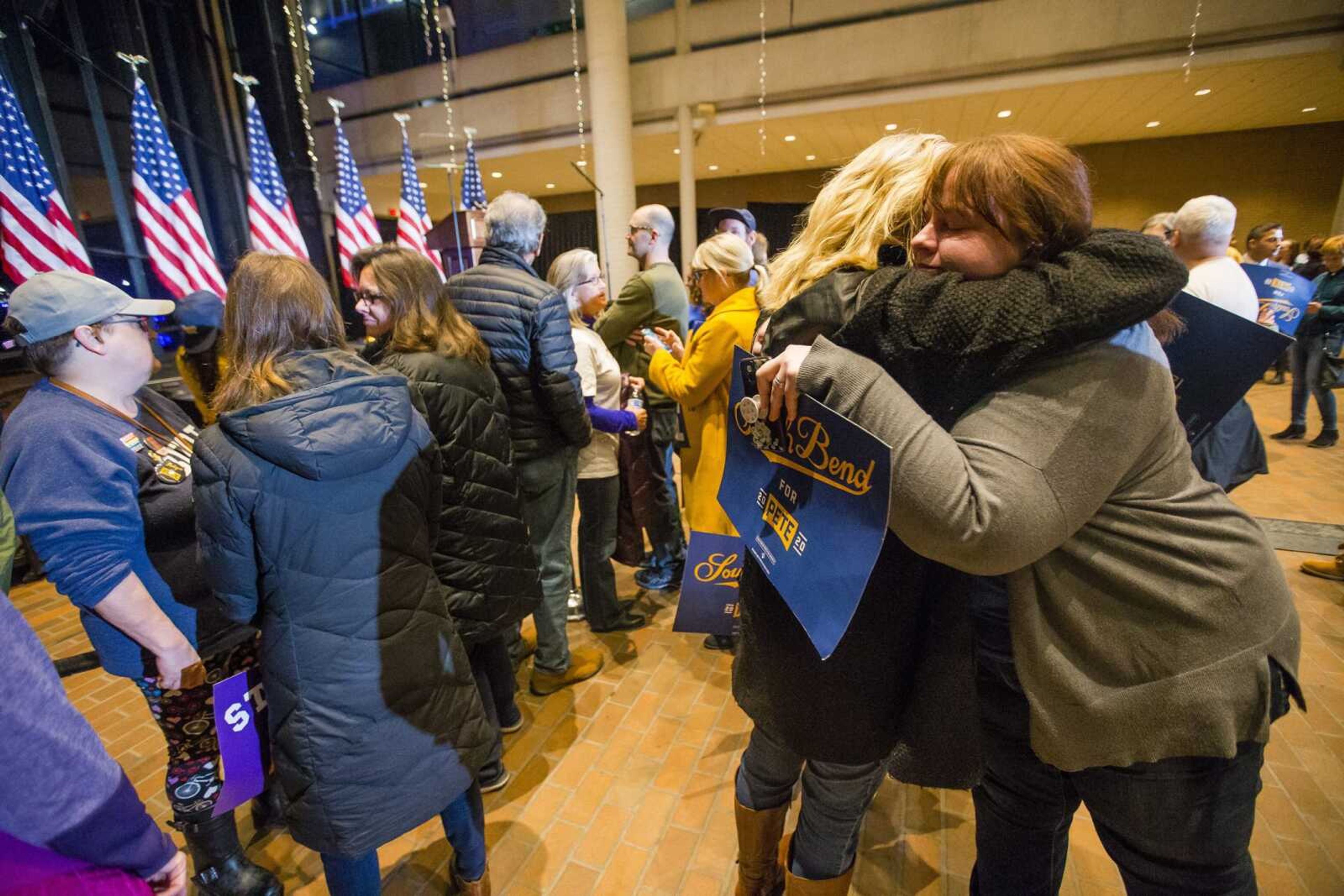 Amanda Govaert Konrath, right, hugs Joy Anderson while they wait for former South Bend Mayor Pete Buttigieg to address the crowd Sunday at Century Center in South Bend, Indiana.