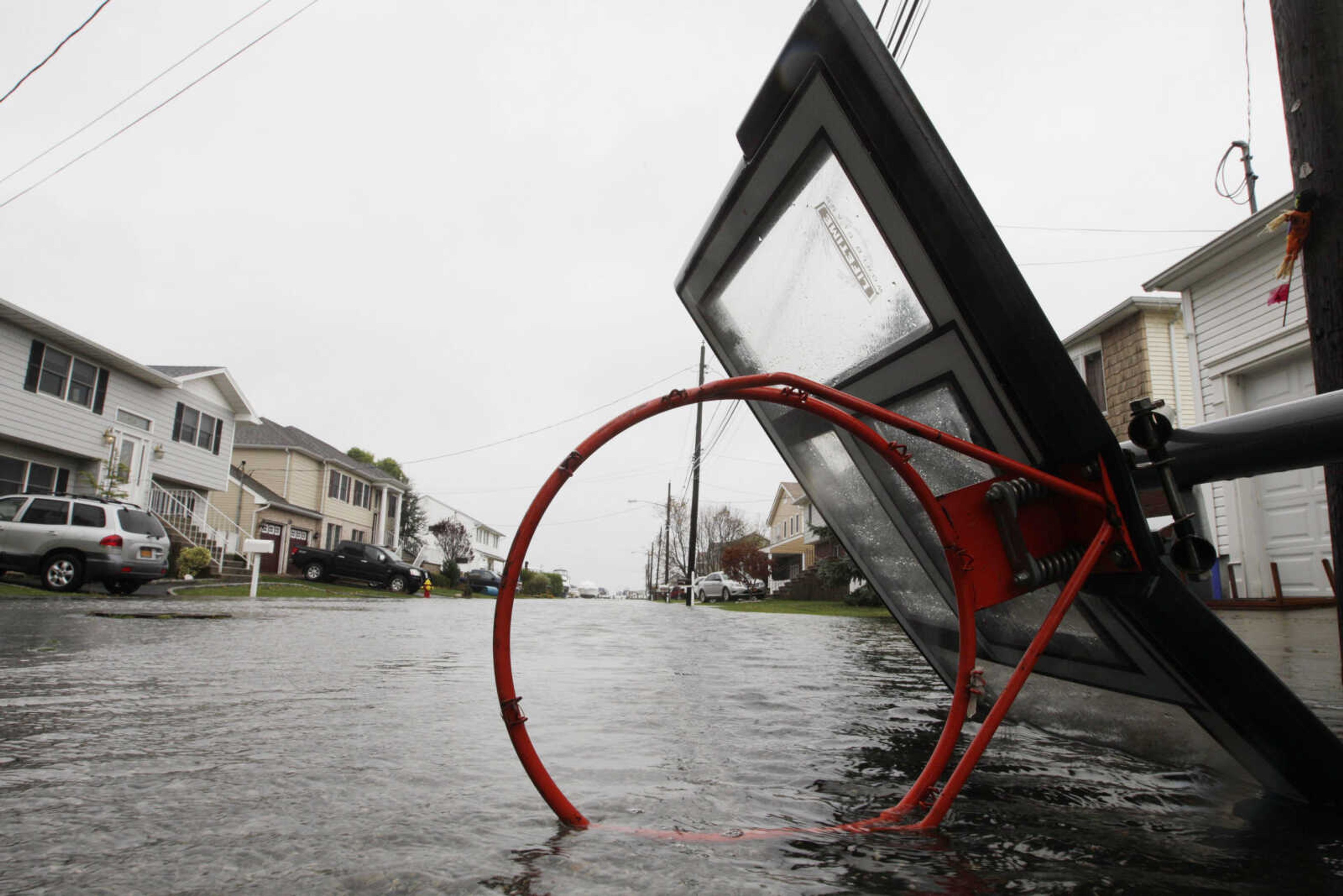 Cars navigate flooded streets Monday, Oct. 29, 2012, in Seaford, N.Y. Hurricane Sandy continued on its path Monday, as the storm forced the shutdown of mass transit, schools and financial markets, sending coastal residents fleeing, and threatening a dangerous mix of high winds and soaking rain.Ę (AP Photo/Gerry Broome)