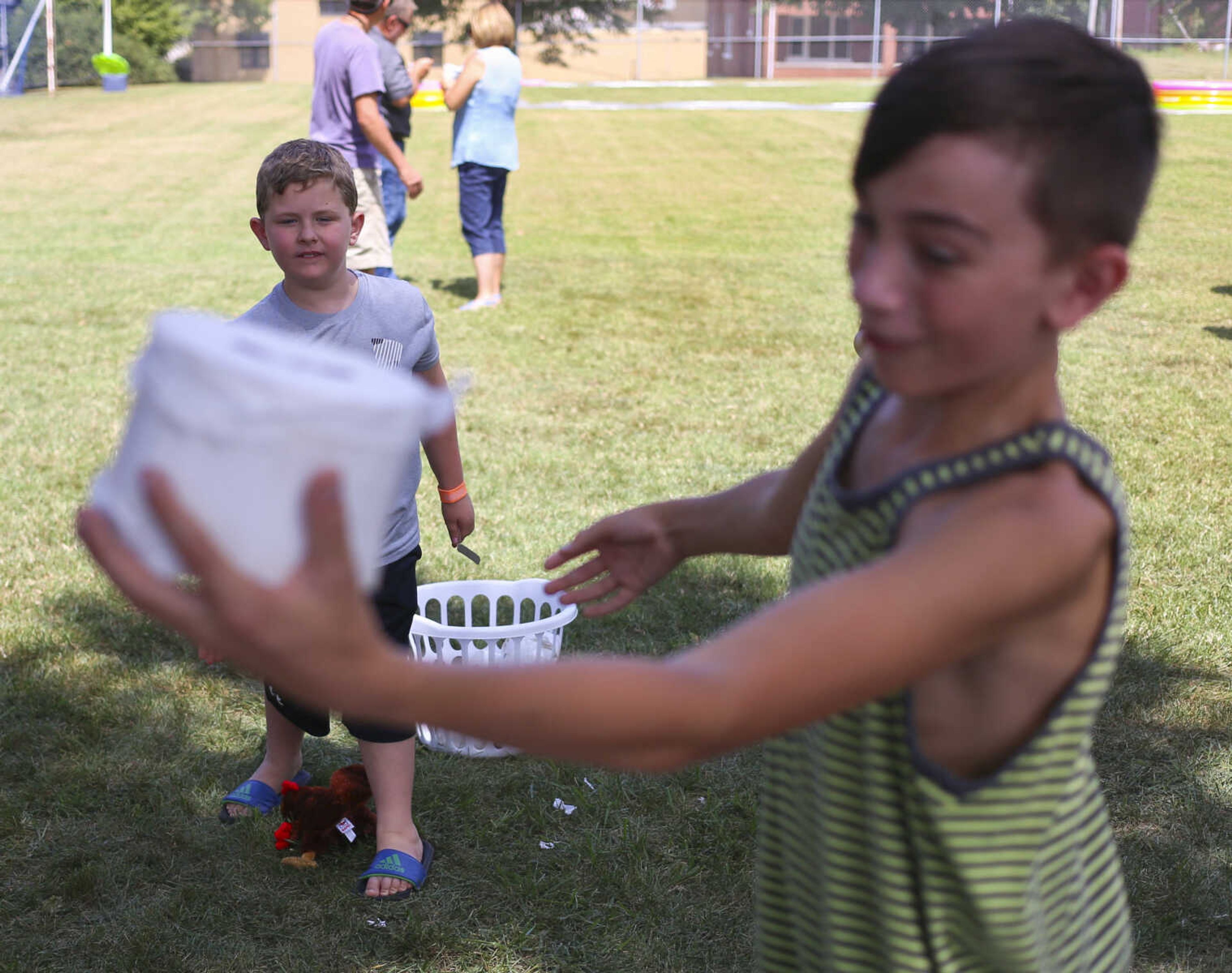 Michael Salter blocks a roll of toilet paper thrown by John Bomar at a "toilet toss" game during the St. Mary Cathedral parish picnic on Sunday, August 27, 2017, in Cape Girardeau.