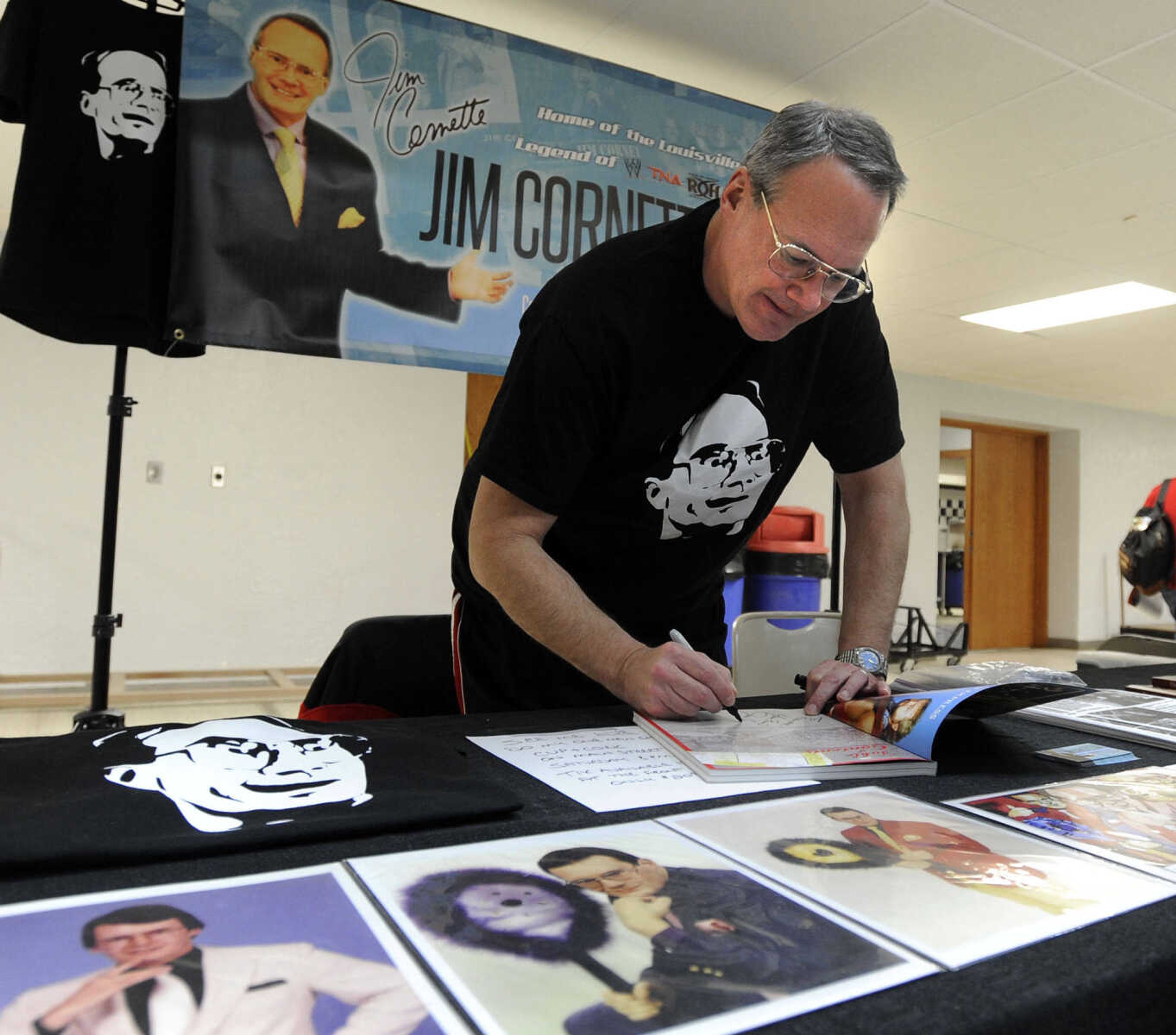 Professional wrestling manager Jim Cornette autographs a book at Cape Comic Con on Saturday, March 22, 2014 at the Arena Building.