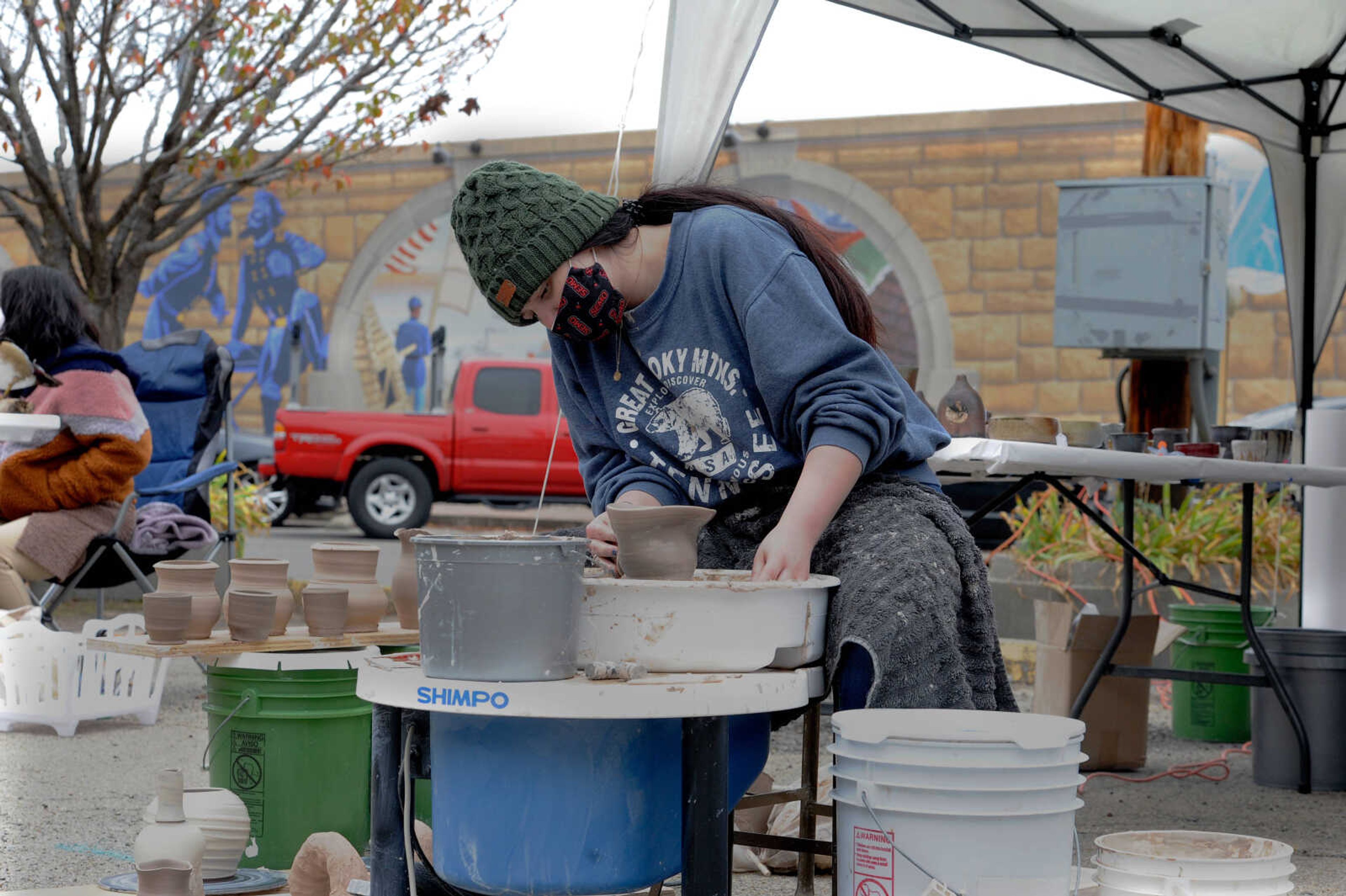 Seraphina McAteer, a member of Clay Club at Southeast Missouri State University, demonstrates how to make pottery at WaterFest, held in the parking lot on the corner of Themis and Water St. in downtown Cape Girardeau on Saturday, Oct. 24, 2020.