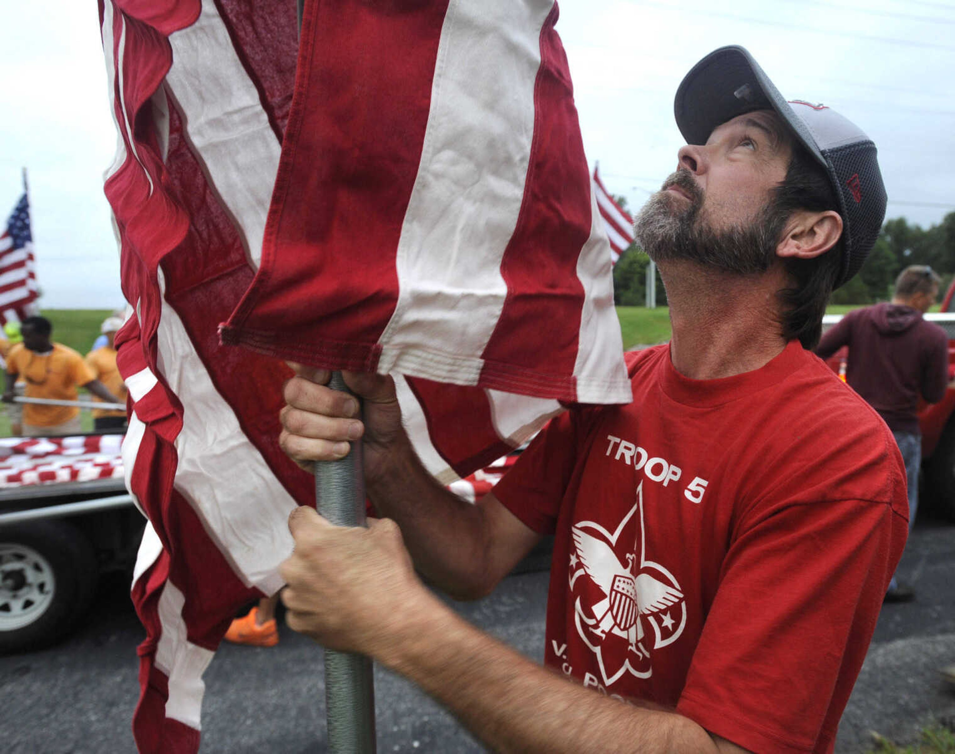 Brian Weiss helps set up the Avenue of Flags on Friday, Sept. 11, 2015 at Cape County Park North.