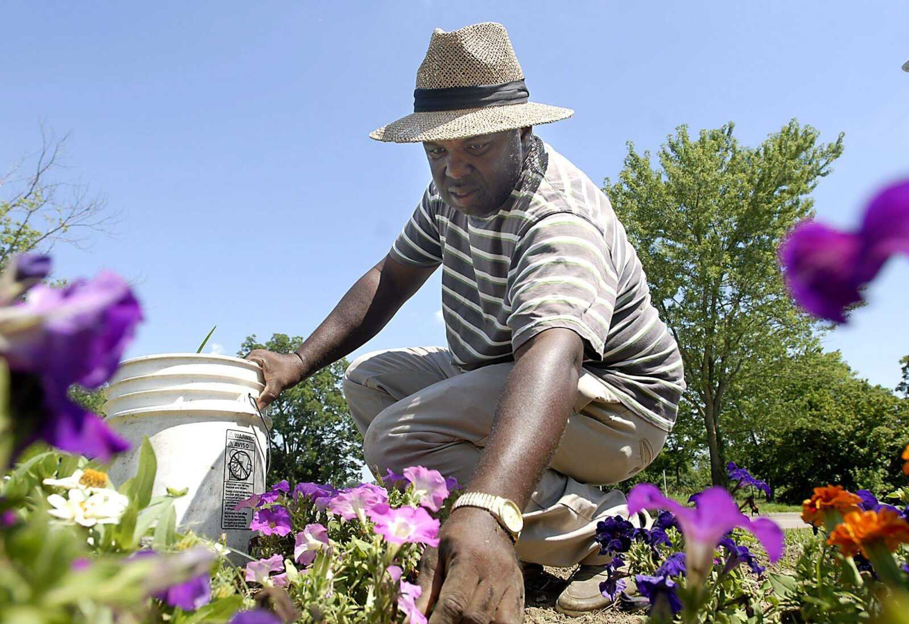 Robert Harris tends to weeds Tuesday afternoon, July 7, 2009, in one of the flower beds at Red Star Community Garden in Cape Girardeau. "I'm always pulling something" said Harris. "That's just what I do." (Kit Doyle)