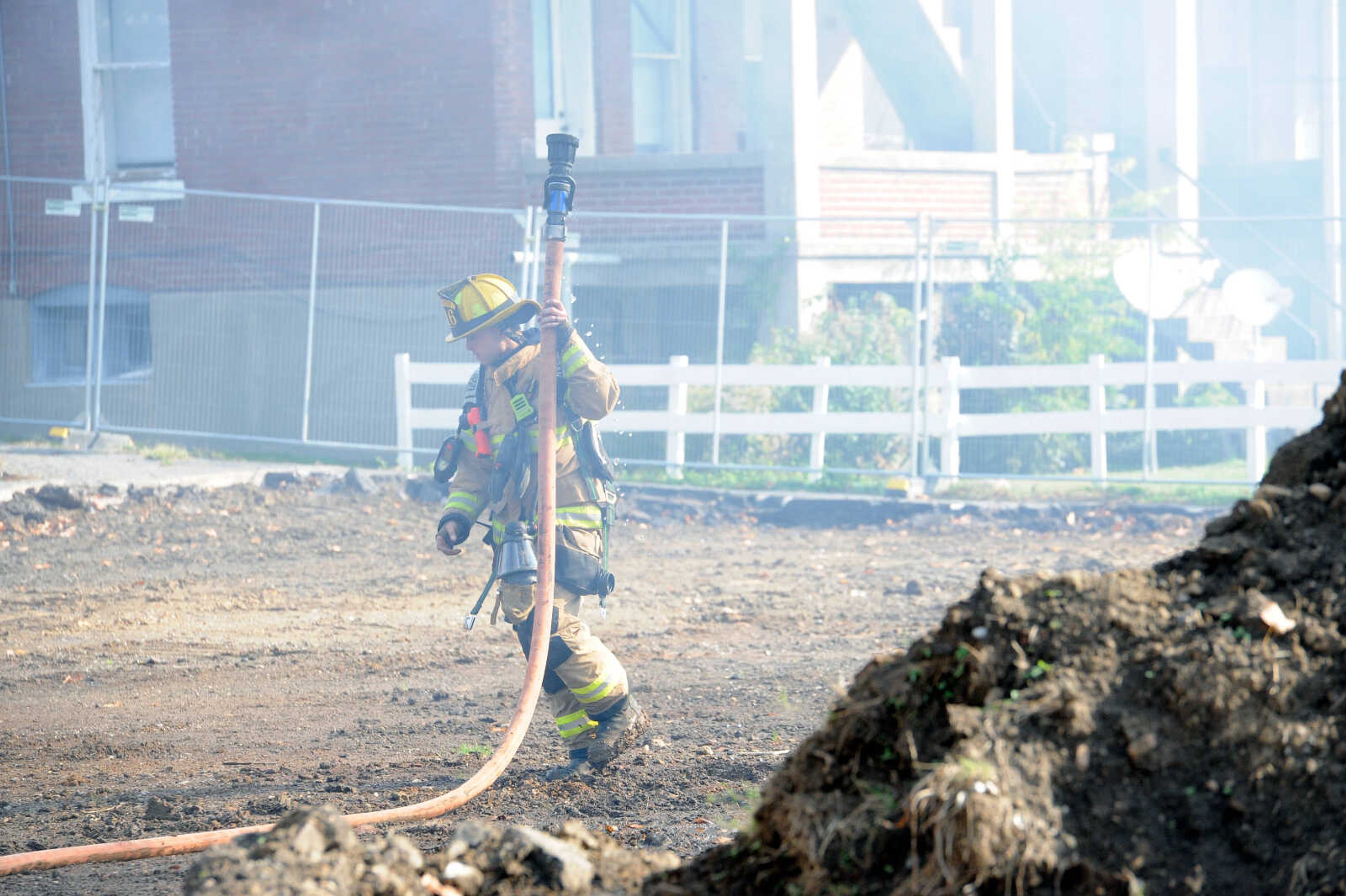 Cape Girardeau firefighter Schneider carries the hose back to the fire truck at the live burn exercise at 222 N. Middle St. on Friday, Oct. 23, 2020, held by the Cape Girardeau Fire Department.&nbsp;