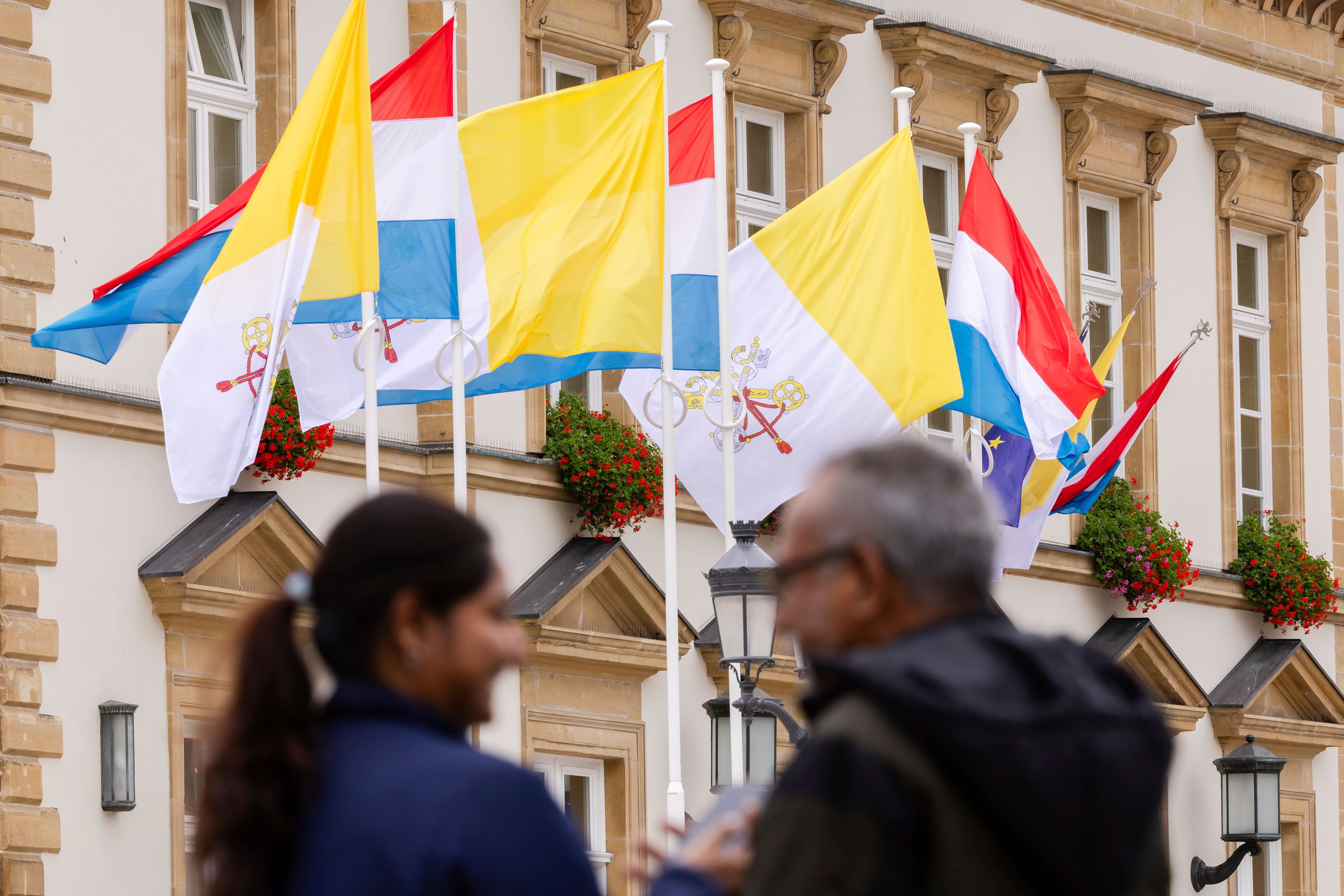 Flags of Vatican City and Luxembourg wave outside the Luxembourg City Hall a day before for the trip of Pope Francis to Luxembourg and Belgium, Wednesday, Sept. 25, 2024, (AP Photo/Geert Vanden Wijngaert)