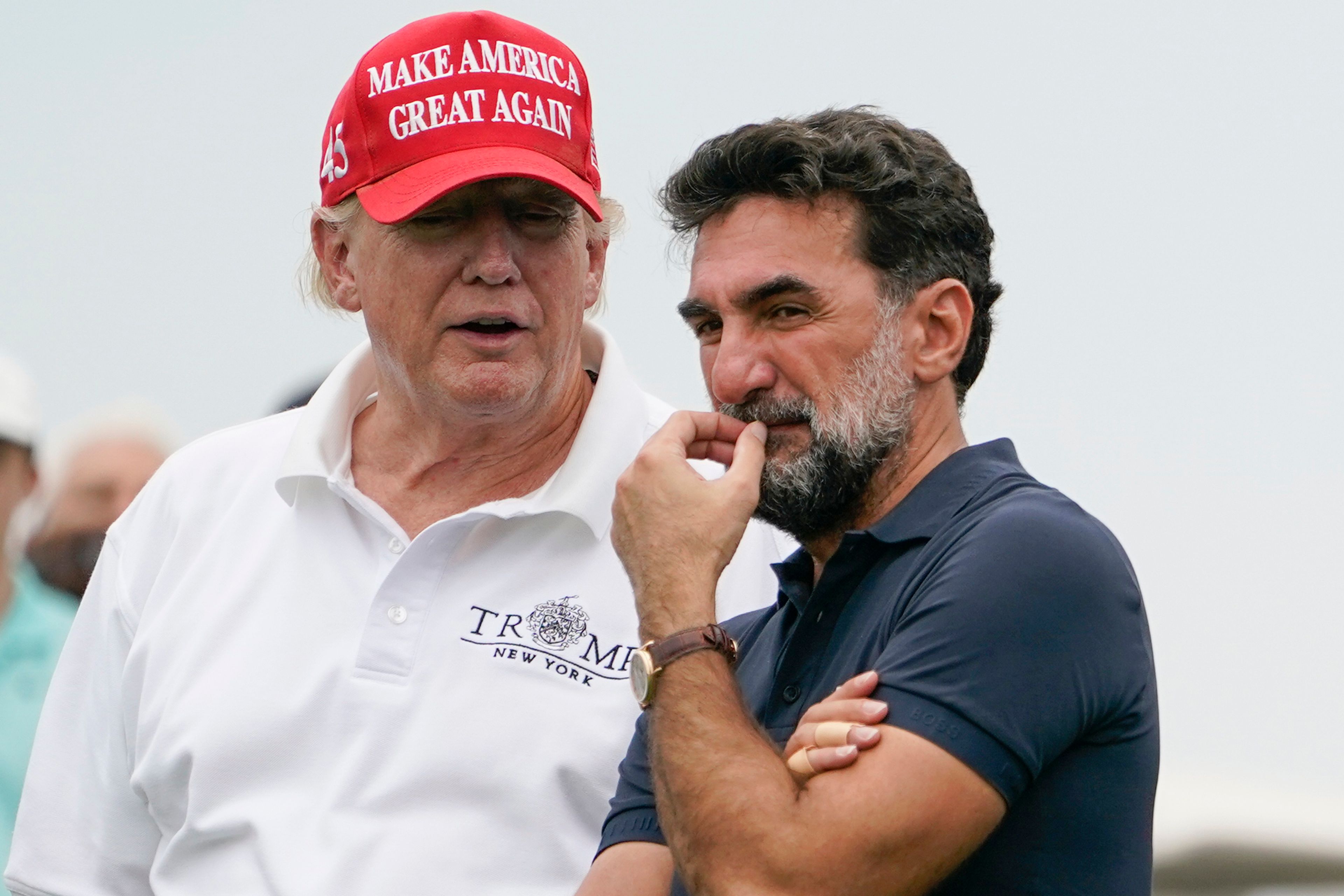 FILE - Former President Donald Trump, left, talks with Yasir Al-Rumayyan, governor of Saudi Arabia's Public Investment Fund, on the 16th hole during the first round of the Bedminster Invitational LIV Golf tournament in Bedminster, NJ., July 29, 2022. (AP Photo/Seth Wenig, File)