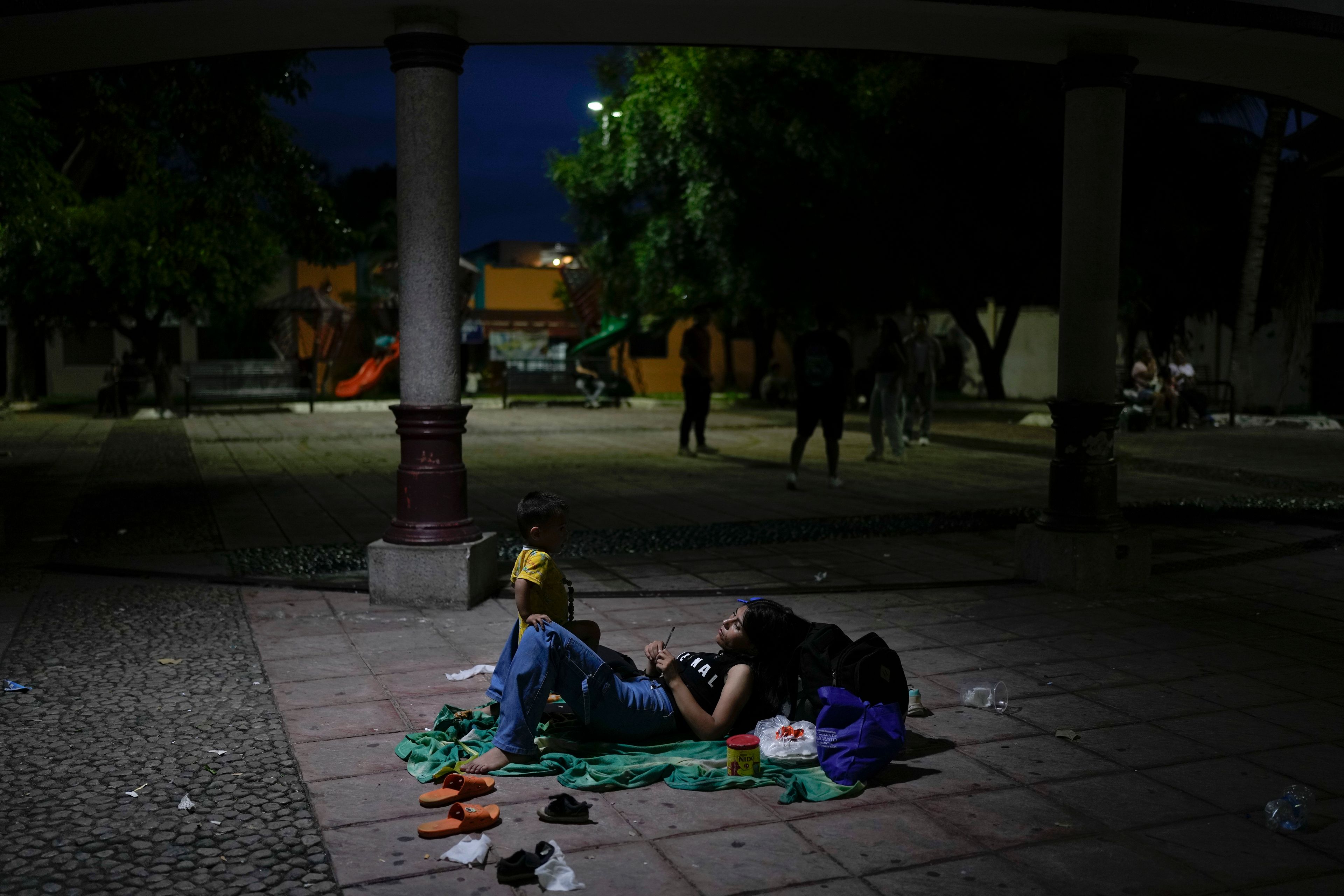 Afghan migrant Khatera Mohammedi and her son Kein camp out in a public square in Tapachula, Mexico, Sunday, Oct. 27, 2024. (AP Photo/Matias Delacroix)