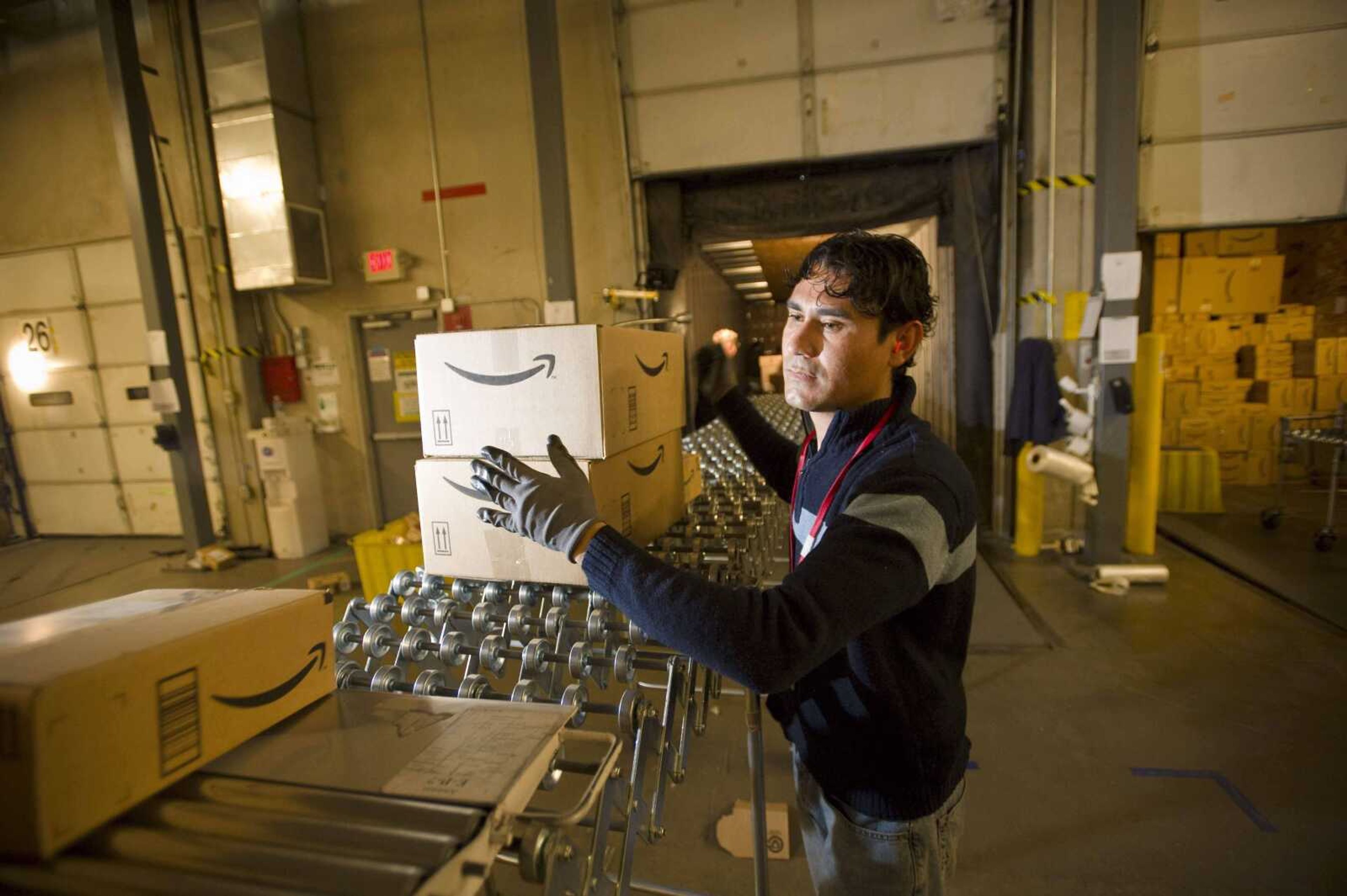 **FILE** In this Dec. 1, 2008 file photo, an Amazon.com employee grabs boxes to be loaded onto a truck at the company's Fernley, Nev. warehouse. States are increasingly looking to collect taxes from online retail sales as a way to fill gaps in budgets, with New York going as far as to pass a bill that requires companies like Amazon.com Inc. to collect taxes on shipments to New York residents, even if the companies' operations are located elsewhere. (AP Photo/Scott Sady, File)