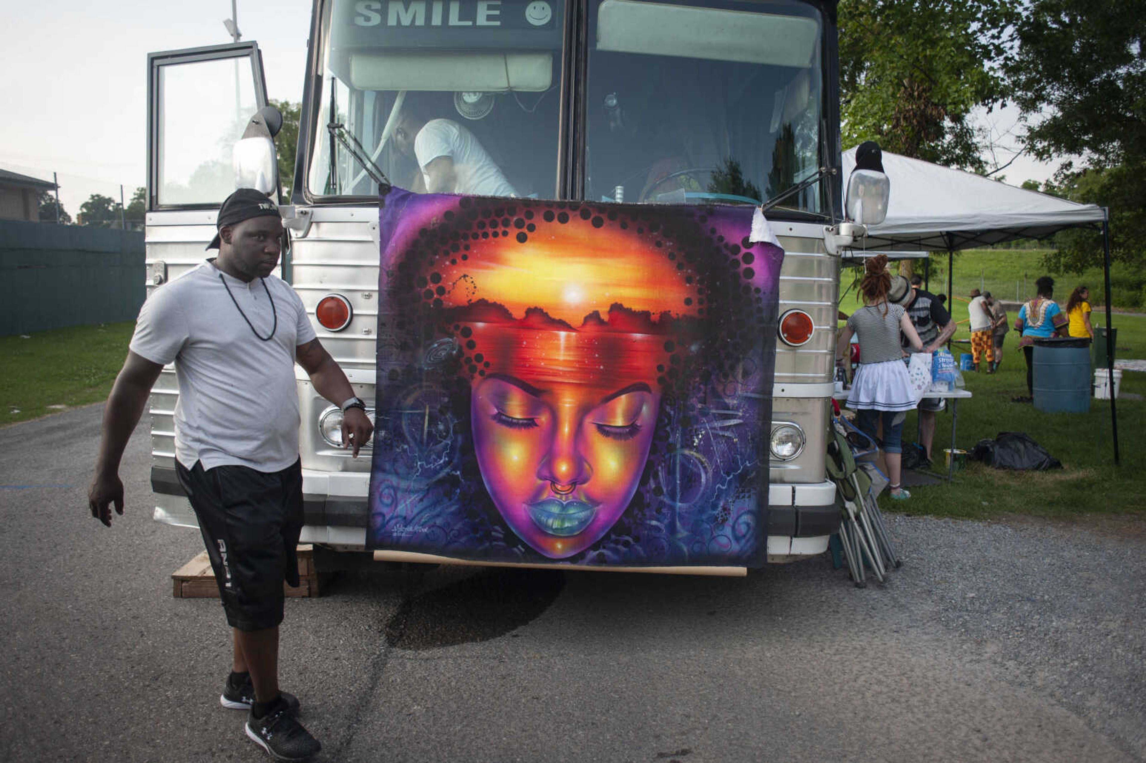 De Von Dent of Milwaukee walks in front of the "Pollination Station" art bus during a Cape Girardeau Community Art Day on Sunday, June 30, 2019, at Ranney Park in Cape Girardeau.