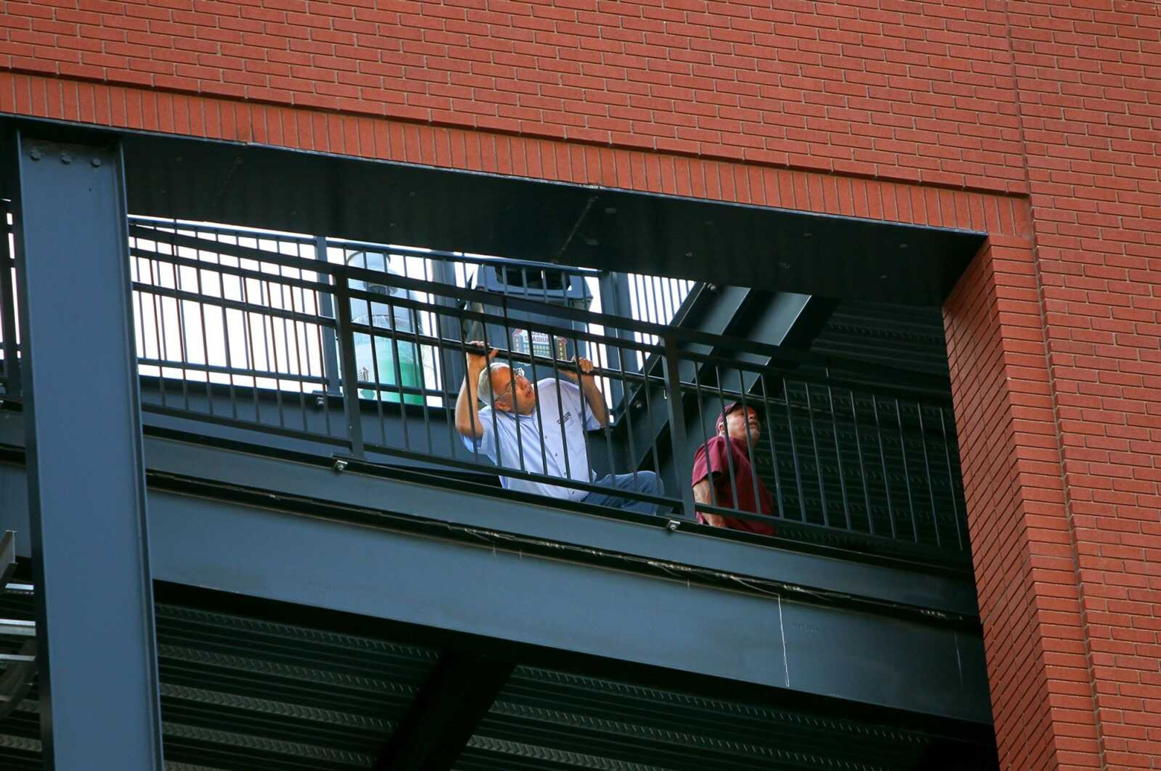 Men inspect metal plates bolted into the concrete Tuesday at Busch Stadium, home of the Cardinals baseball team, in St. Louis. Inspectors are checking the stadium after a piece of metal trim fell from the west side of the building Monday. (David Carson ~ St. Louis Post Dispatch)