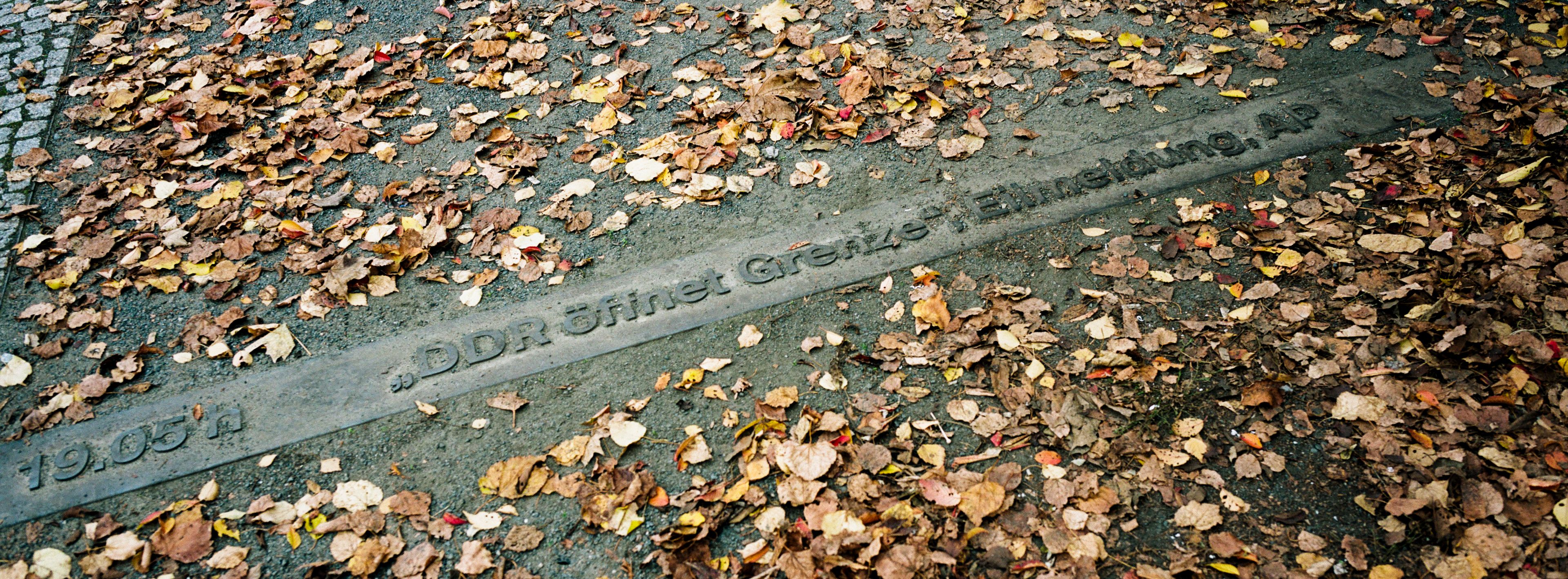 The inscription " At 19:05 The DDR (former East Germany) opens its borders - news alert of the AP" is embedded in the ground near the former border checkpoint between East and West at Bornholmer Strasse in Berlin, Germany, Thursday, Oct. 31, 2024. (AP Photo/Markus Schreiber)