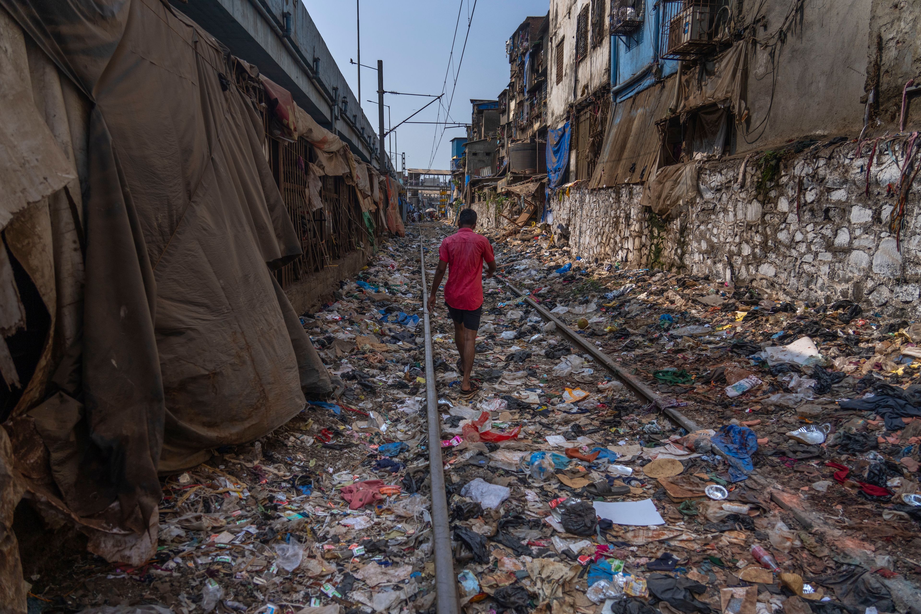 FILE - A man walks on a railway track littered with plastic and other waste materials on Earth Day in Mumbai, India, April 22, 2024. (AP Photo/, File)