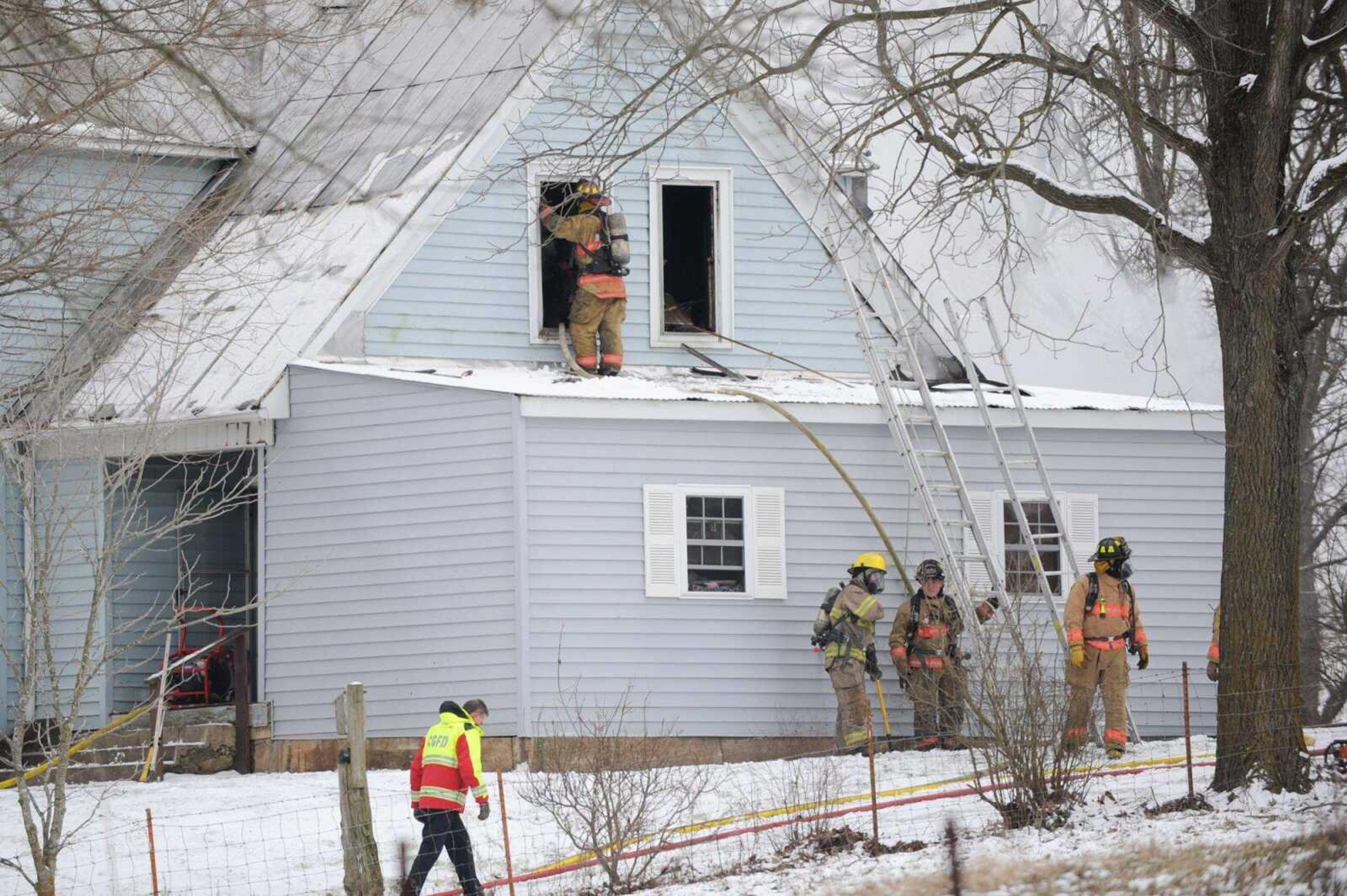 First responders work to extinguish a fire that broke out at a two-story home Thursday, Jan. 21, 2016 near Gordonville.