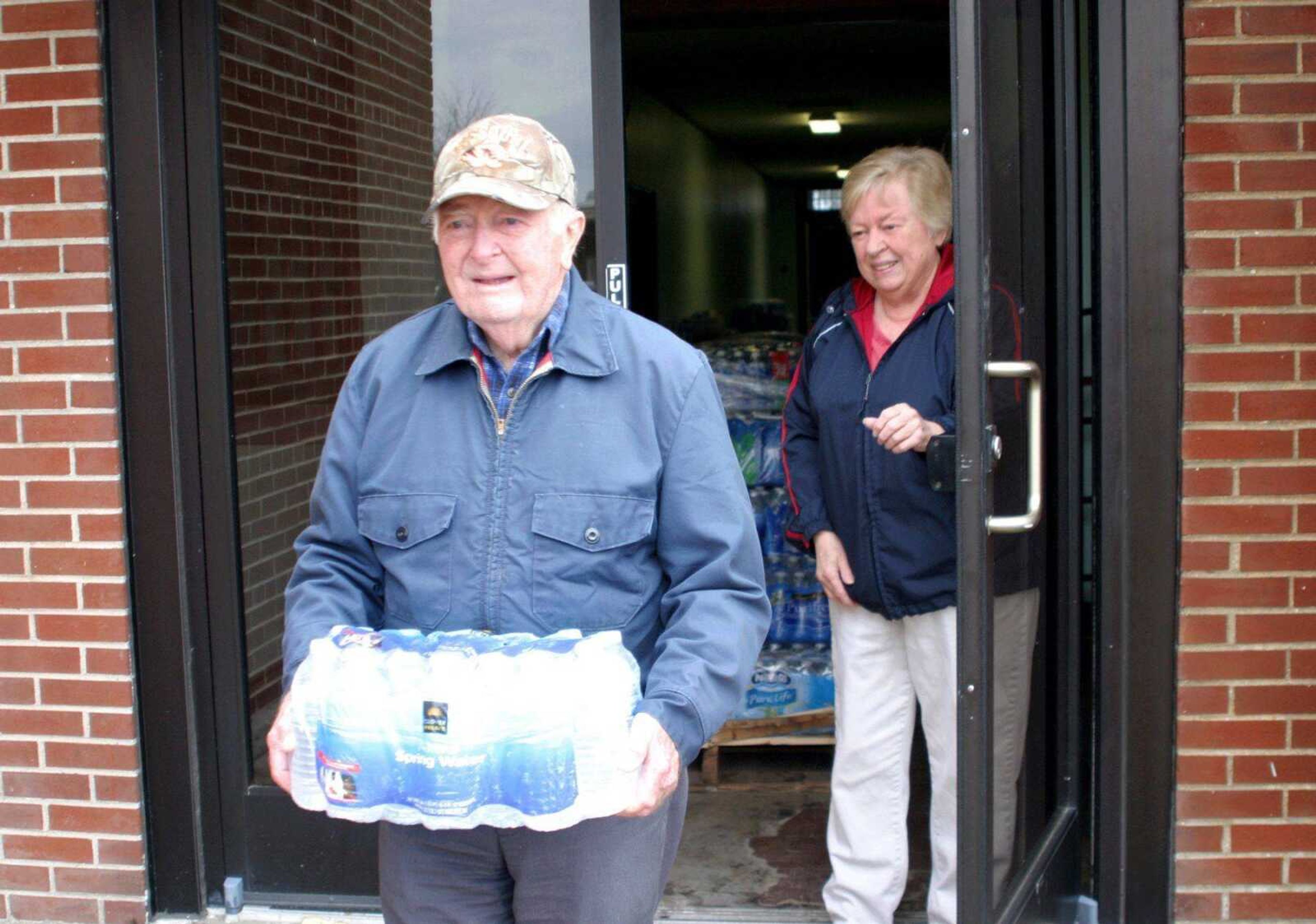 Jim and Mary Greene of Morehouse, Mo., collect a case of drinking water from city hall Friday. Hope International donated the water to help the town's residents through a boil-water order. (Scott Welton ~ Standard Democrat)