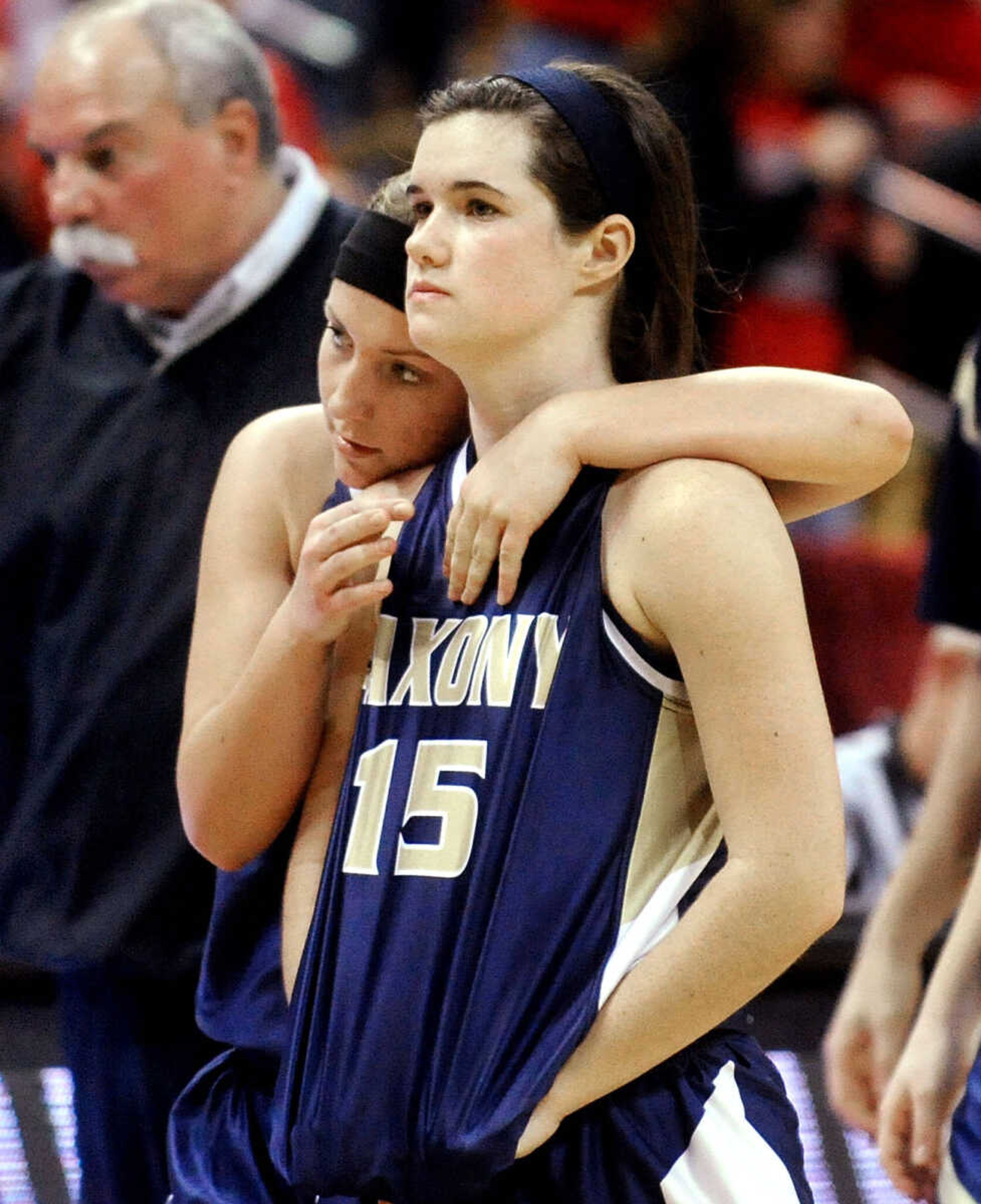 Saxony Lutheran's Grace Mirly hugs teammate Brianna Mueller as they exit the court following the Crusaders' 59-38 loss to El Dorado Springs in the Class 3 state semifinal, Thursday, March 13, 2014, in Columbia, Mo. (Laura Simon)