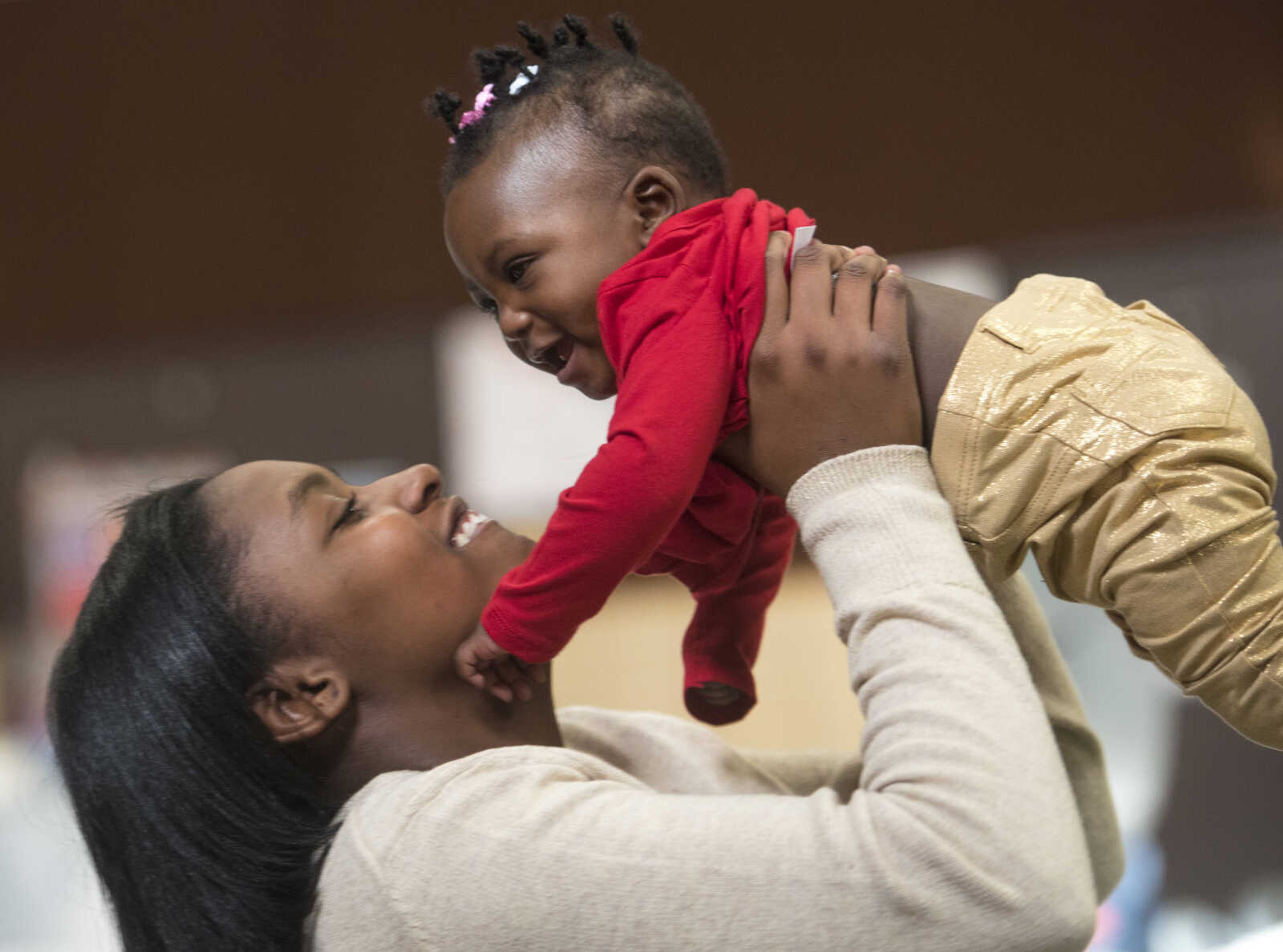 Tamia Blissett, 14, plays with 7-month-old Mi'kela Anderson during a free lunch hosted by Student Santas on Dec. 25, 2017, at Jefferson Elementary School in Cape Girardeau.