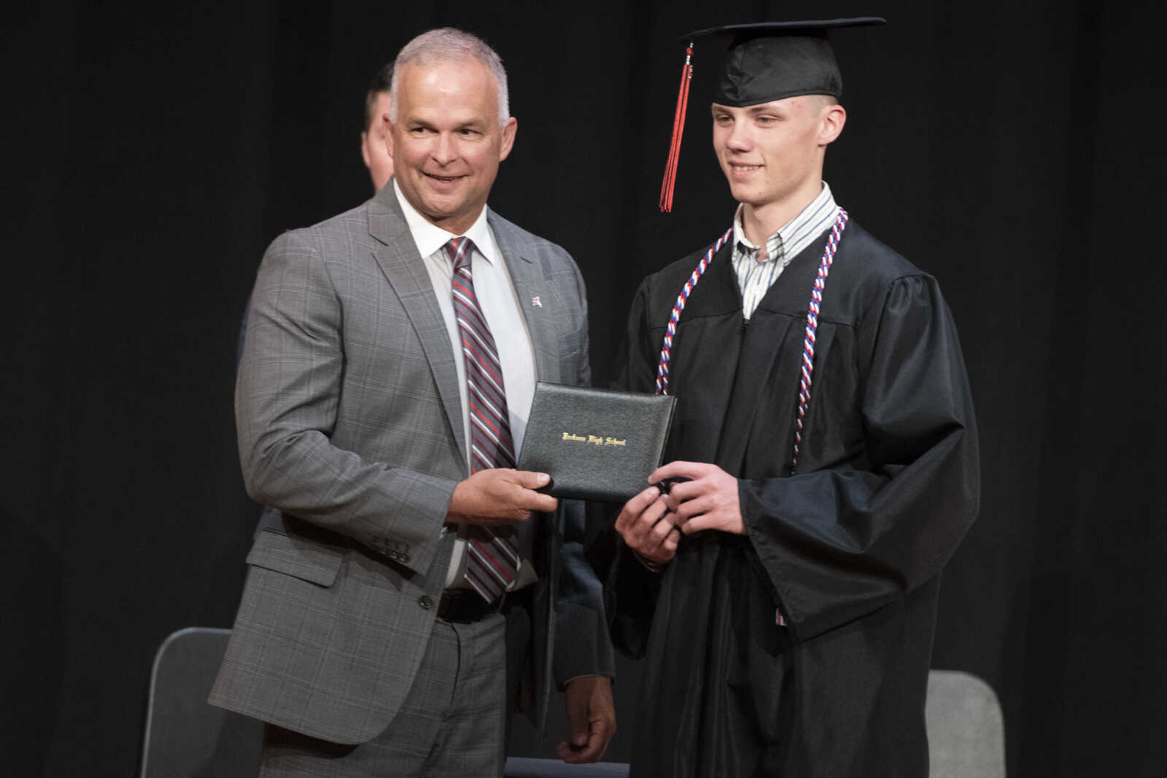 Jackson High School graduate Jacob Charles Farrar has his picture made with Kelly Waller, president of the board of education, during an in-person military graduation ceremony Friday, May 22, 2020, at Jackson High School.