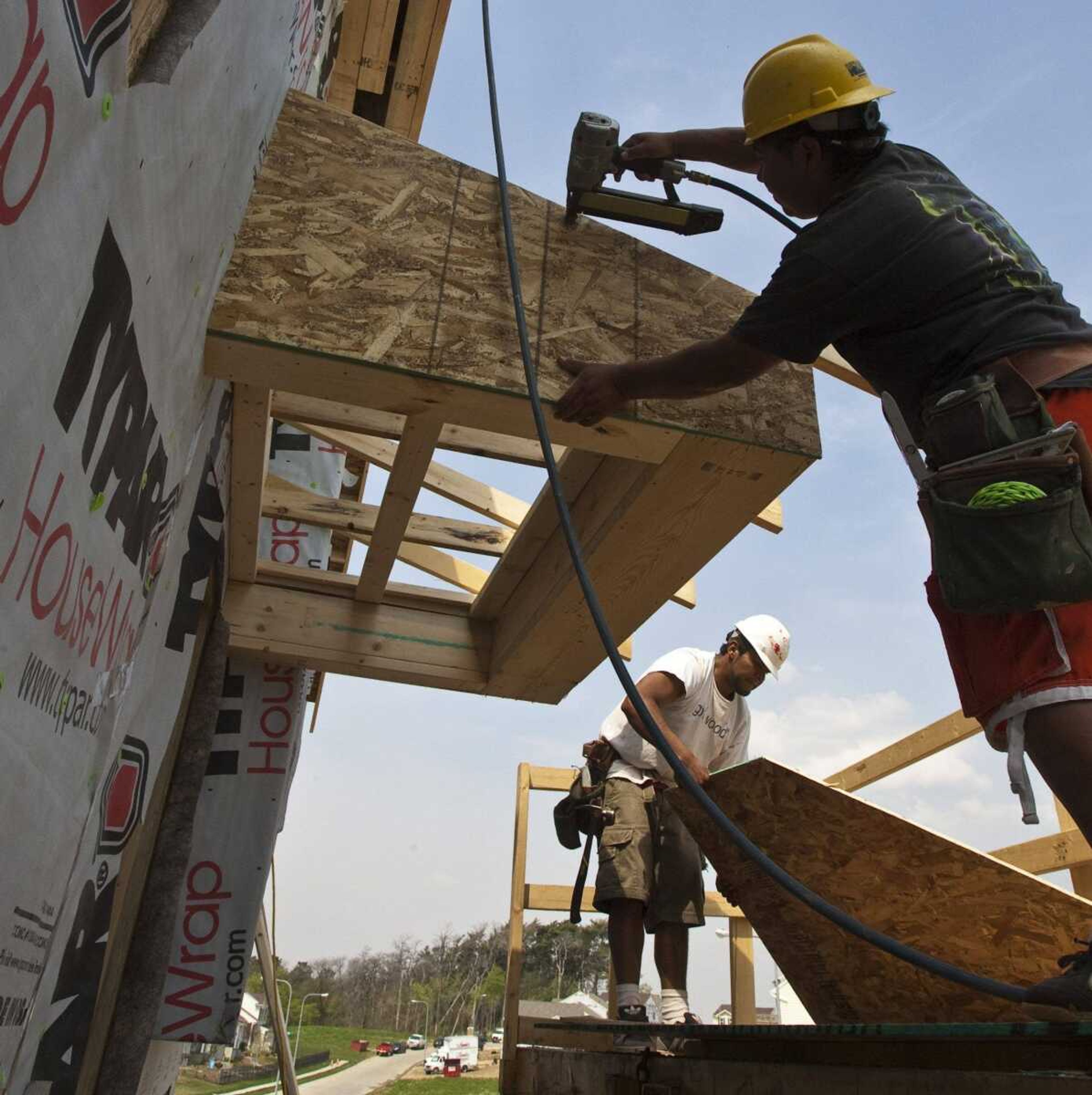 A crew works on a new home Tuesday in Omaha, Neb. First-time claims for jobless benefits fell sharply last week, evidence that employers are cutting fewer workers as the economy recovers. (Nati Harnik ~ Associated Press)