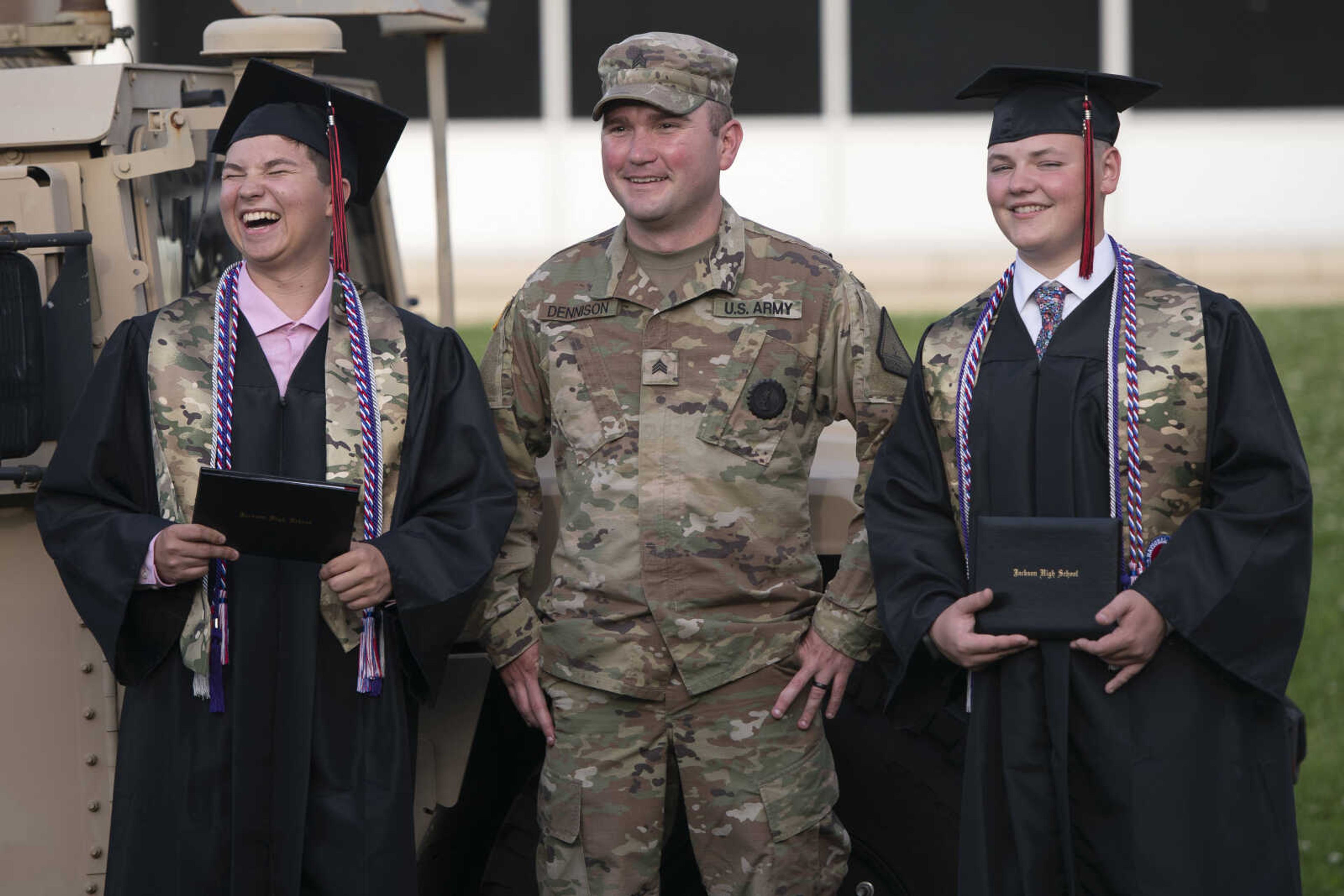 Jackson High School graduates Logan Wayne McClanahan (left) and Caleb Scott Anderson (right) take pictures with Missouri National Guard member James Dennison (middle) following an in-person military graduation ceremony and parade Friday, May 22, 2020, at Jackson High School.